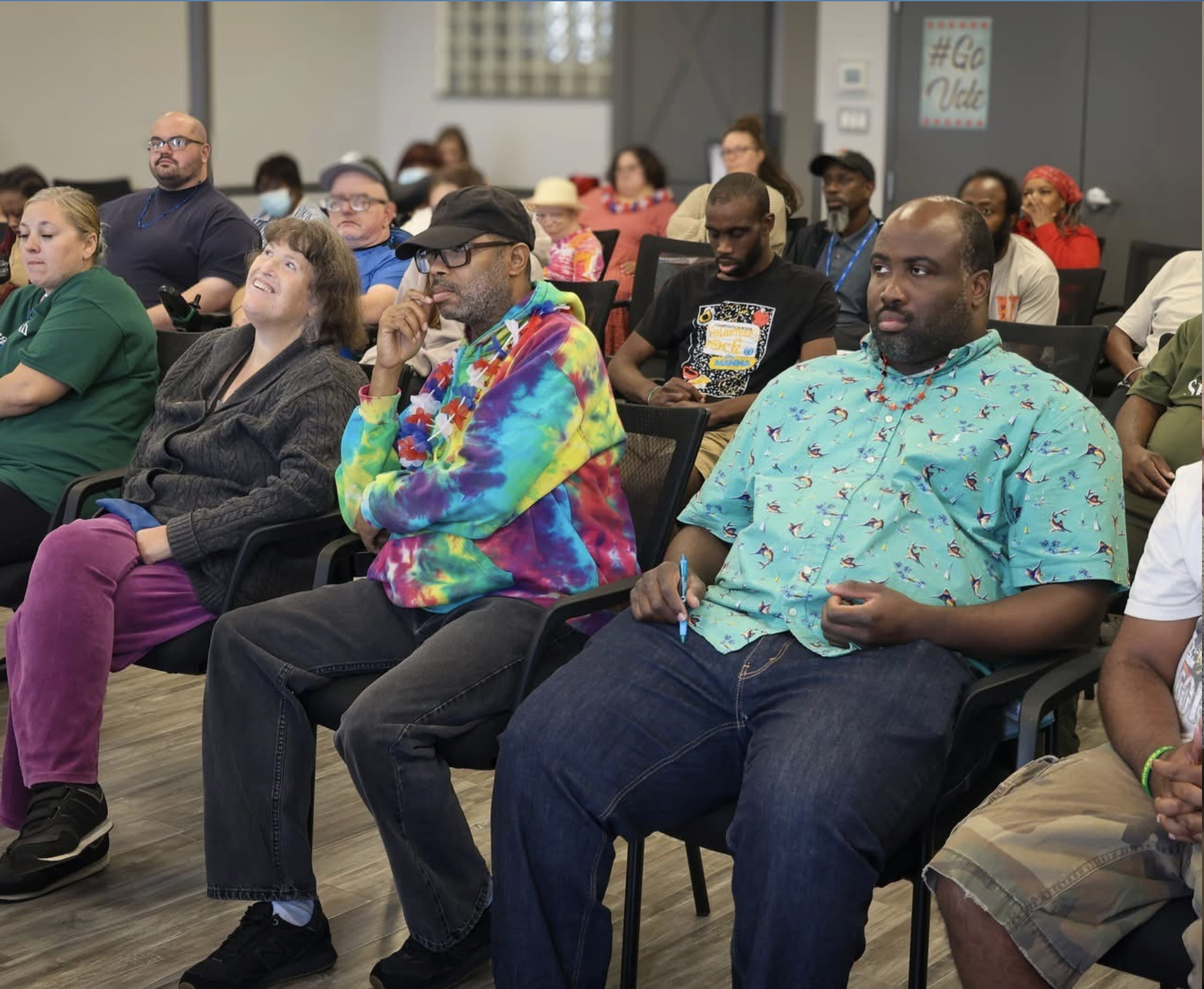 A group of people sit and listen during an informational session through "Speaking For Ourselves".