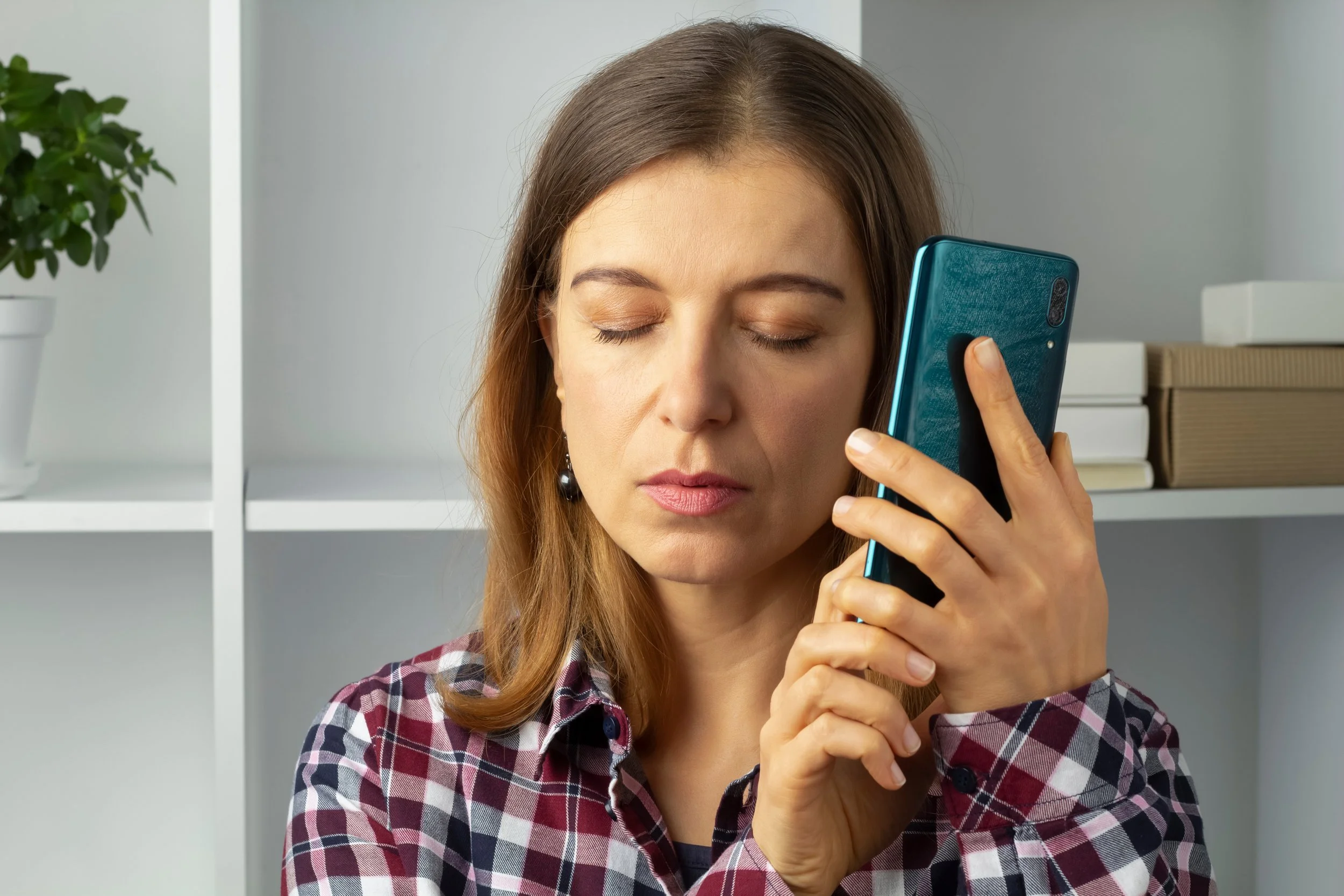 A blind woman listens to the screen reader on her phone.