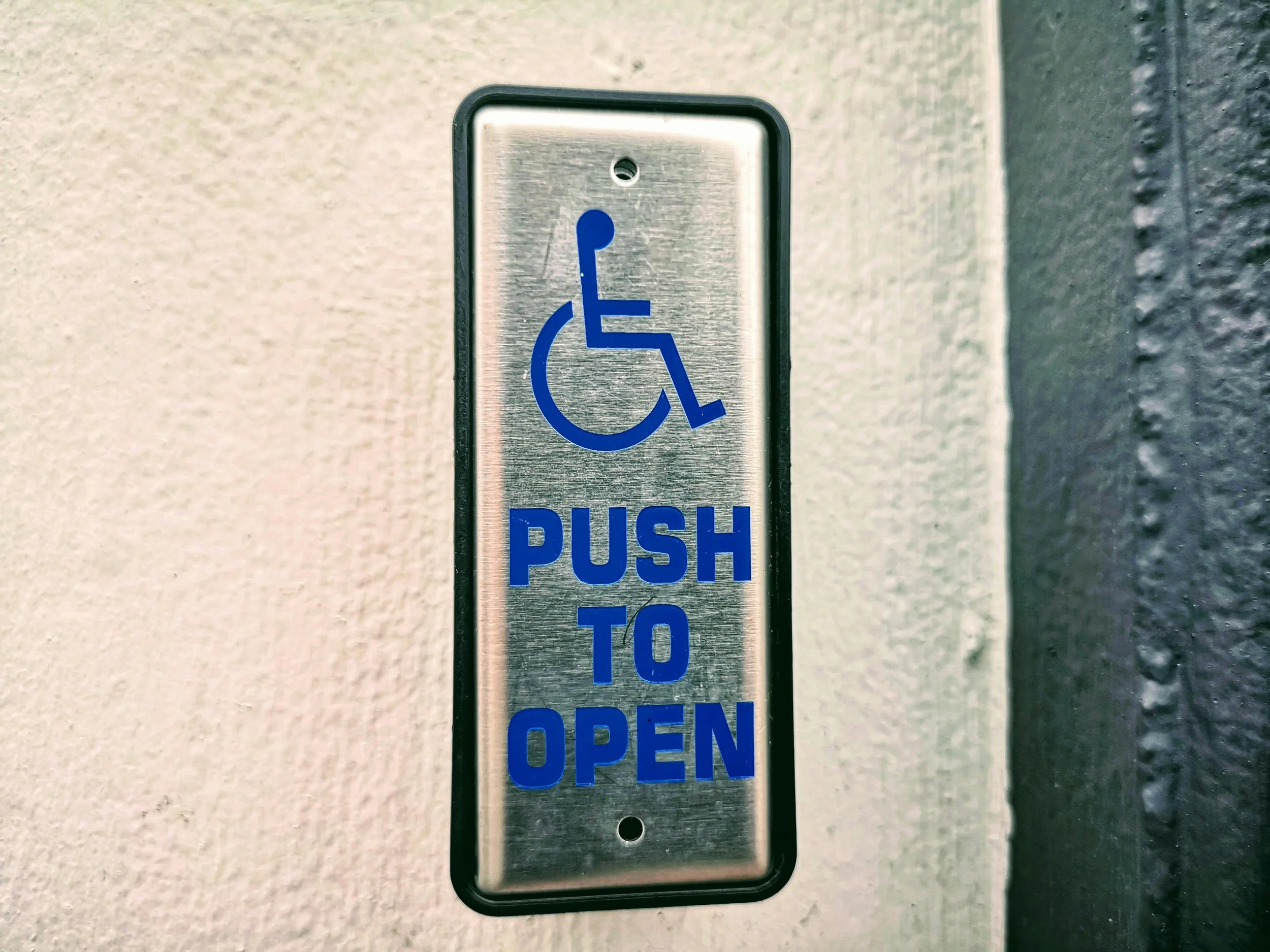 A button to press to automatically open doors for wheelchair access is pictured.