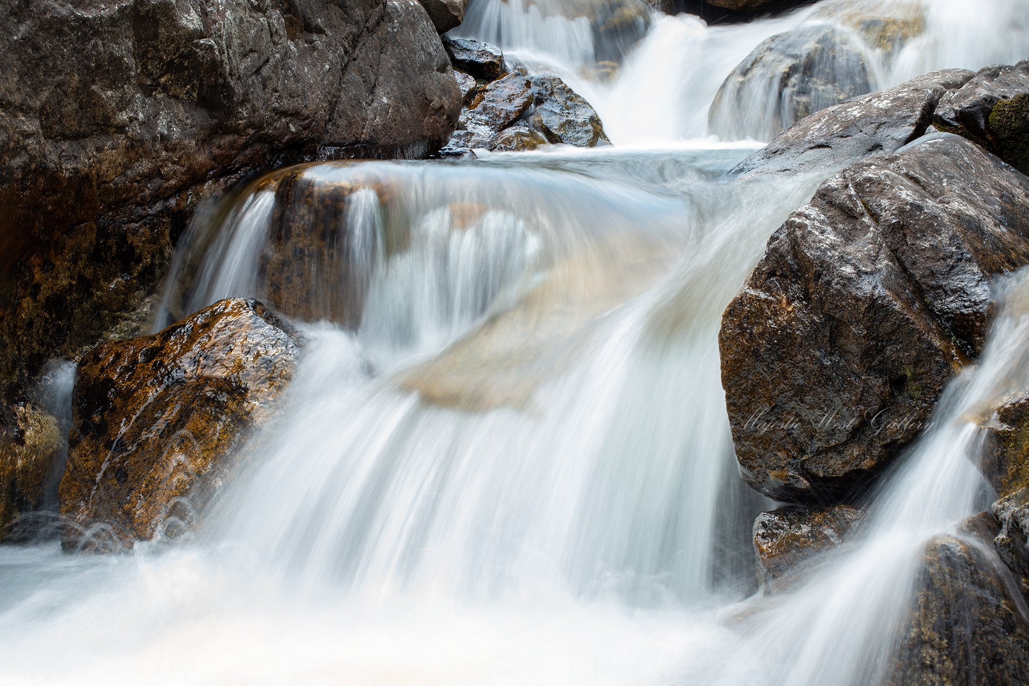 Peaceful and serene flowing water gently cascading over rocks in Montana, available for purchase as wall art