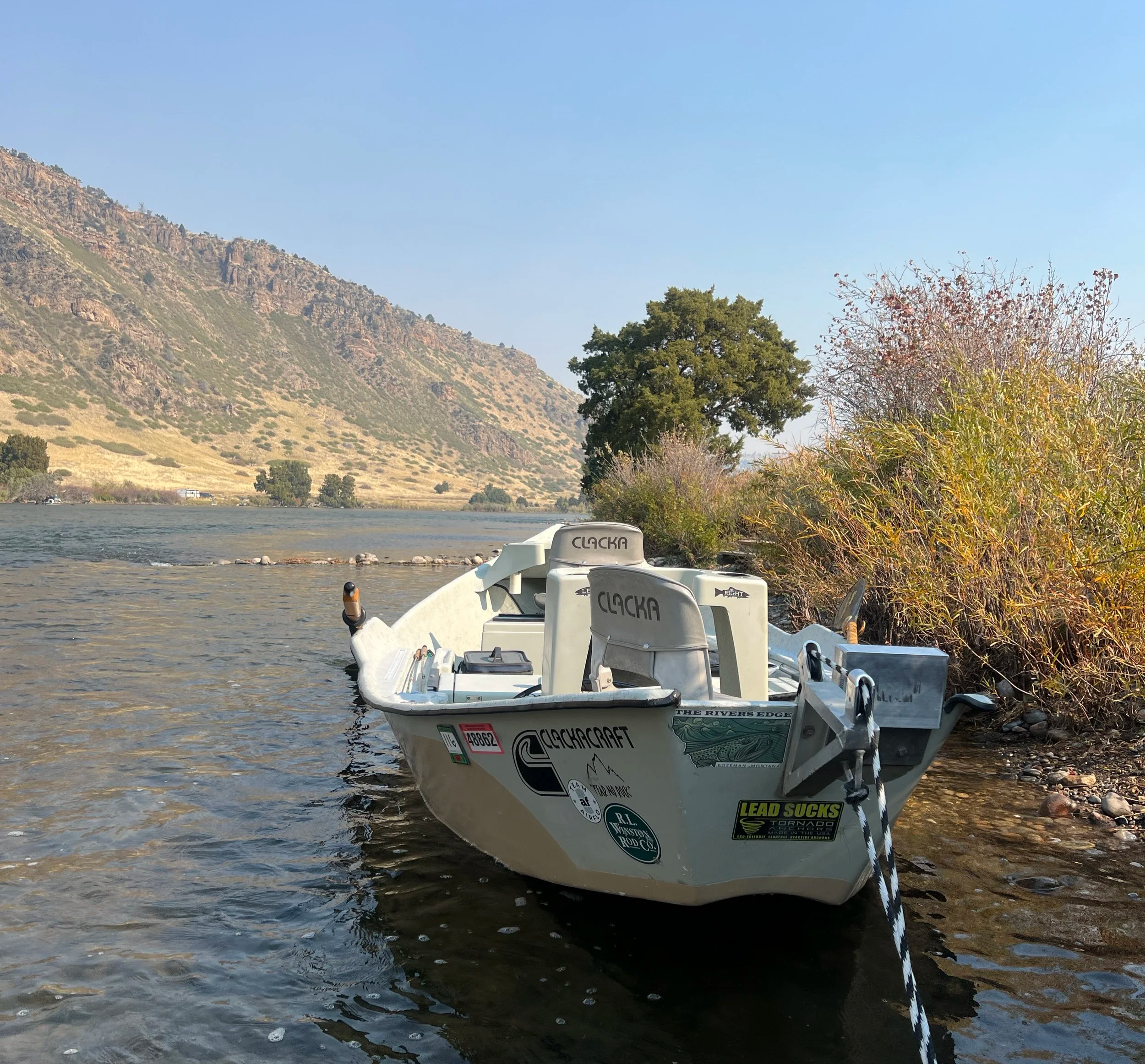 Driftboat pulled over on the side of the lower madison river in montana