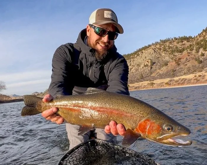 Owner, Outfitter and Guide Mike Pogoda of Rising Trout Fly Fishing Outfitters holding a big rainbow trout on the Missouri River in Montana