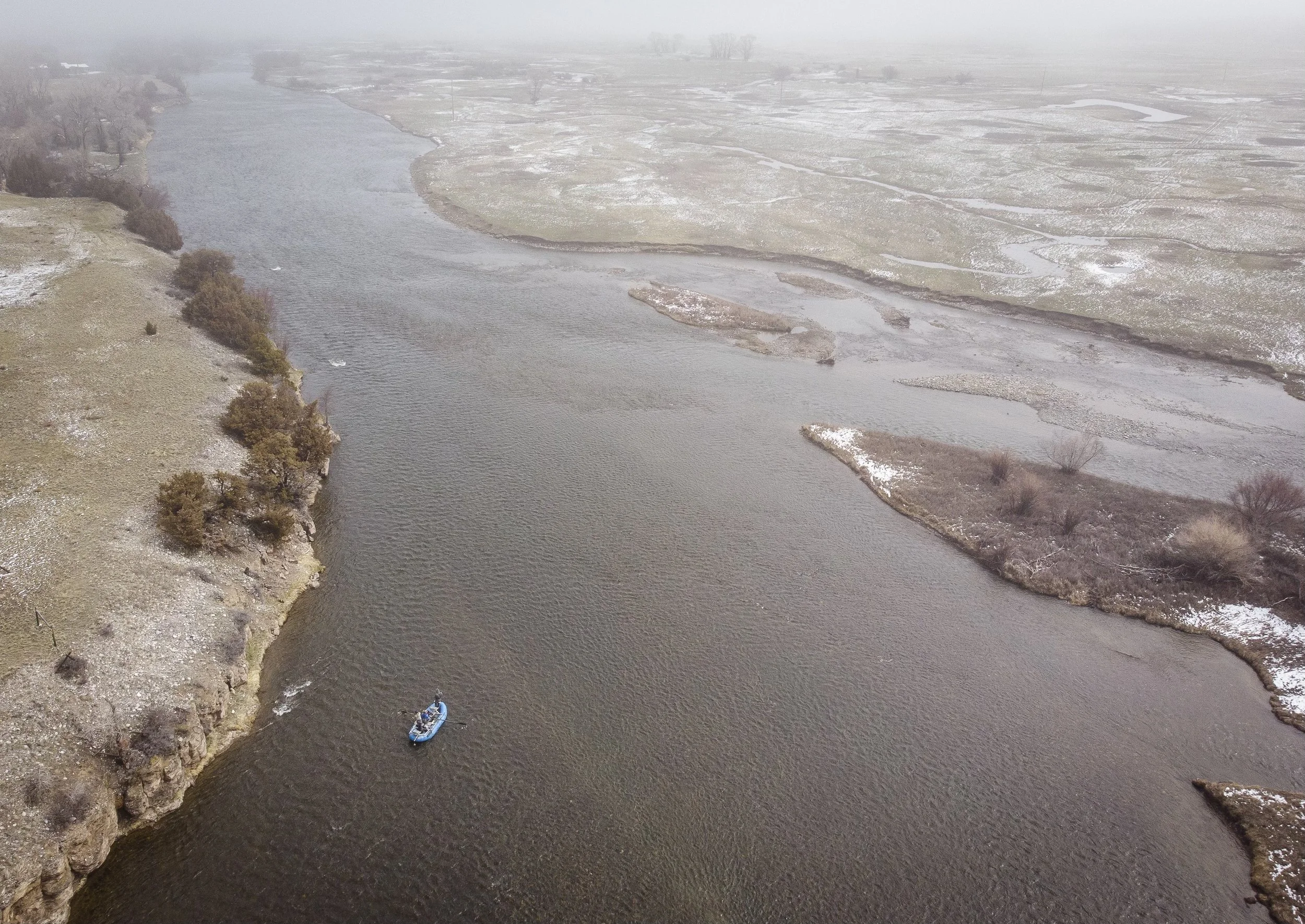 aerial photo of a raft floating down the upper madison river in montana