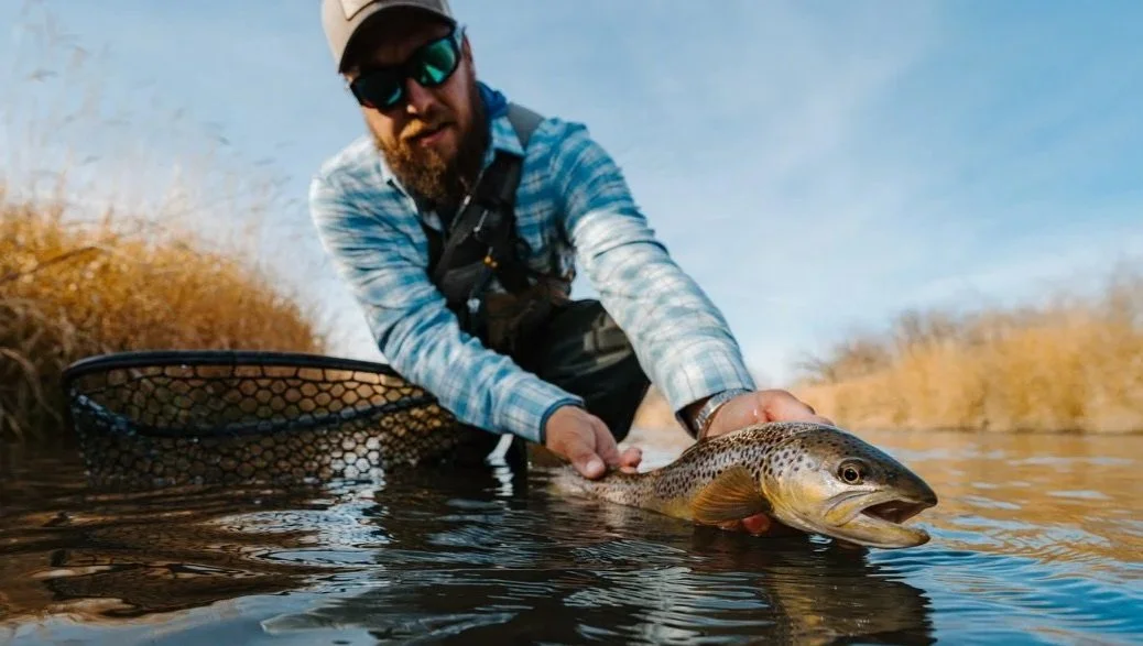 fly fishing guide holding a montana brown trout