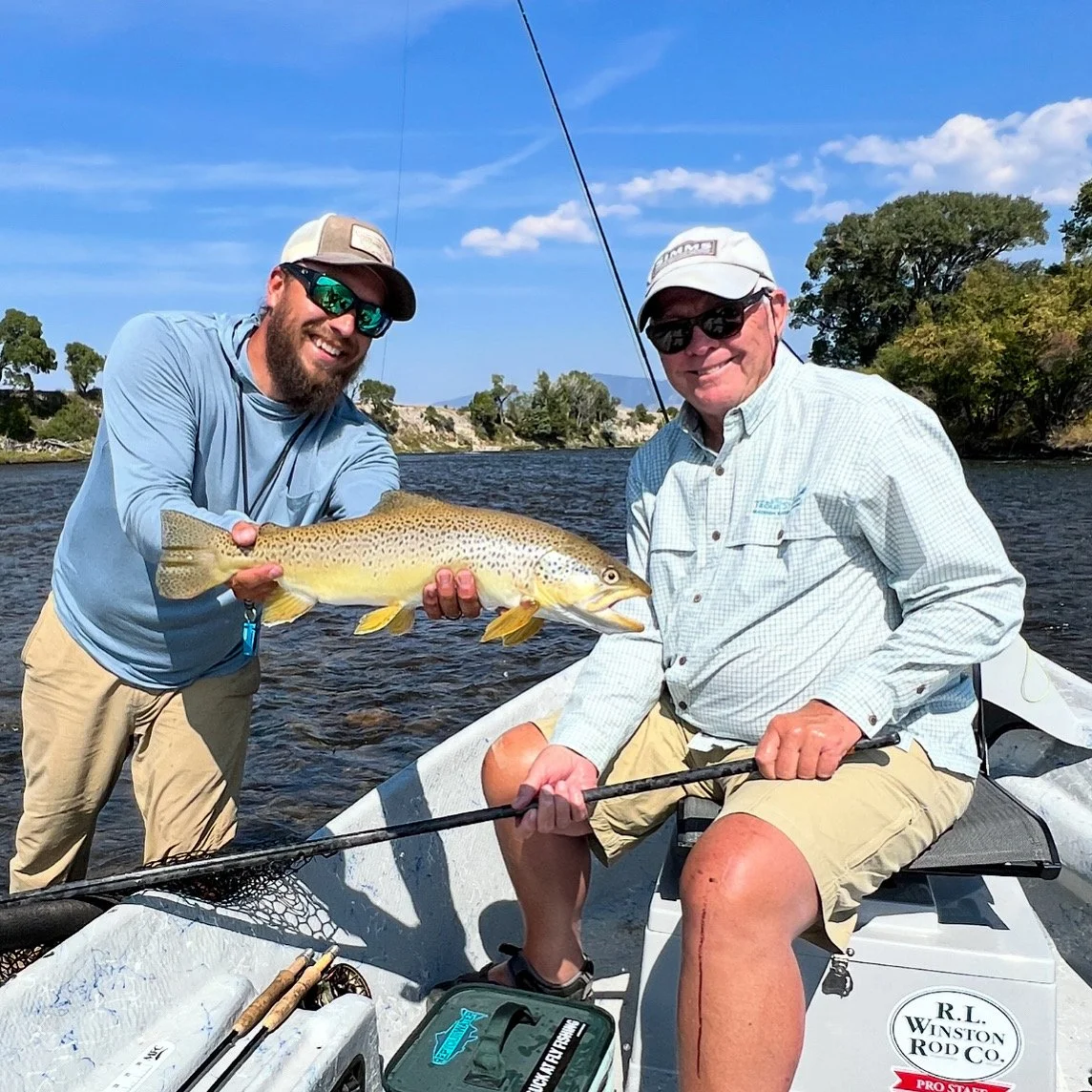 Guided fly fishing trip on Montana’s Madison River — happy angler and guide holding a trophy brown trout with Bozeman fly fishing guide and outfitter Mike Pogoda from Rising Trout Outfitters.