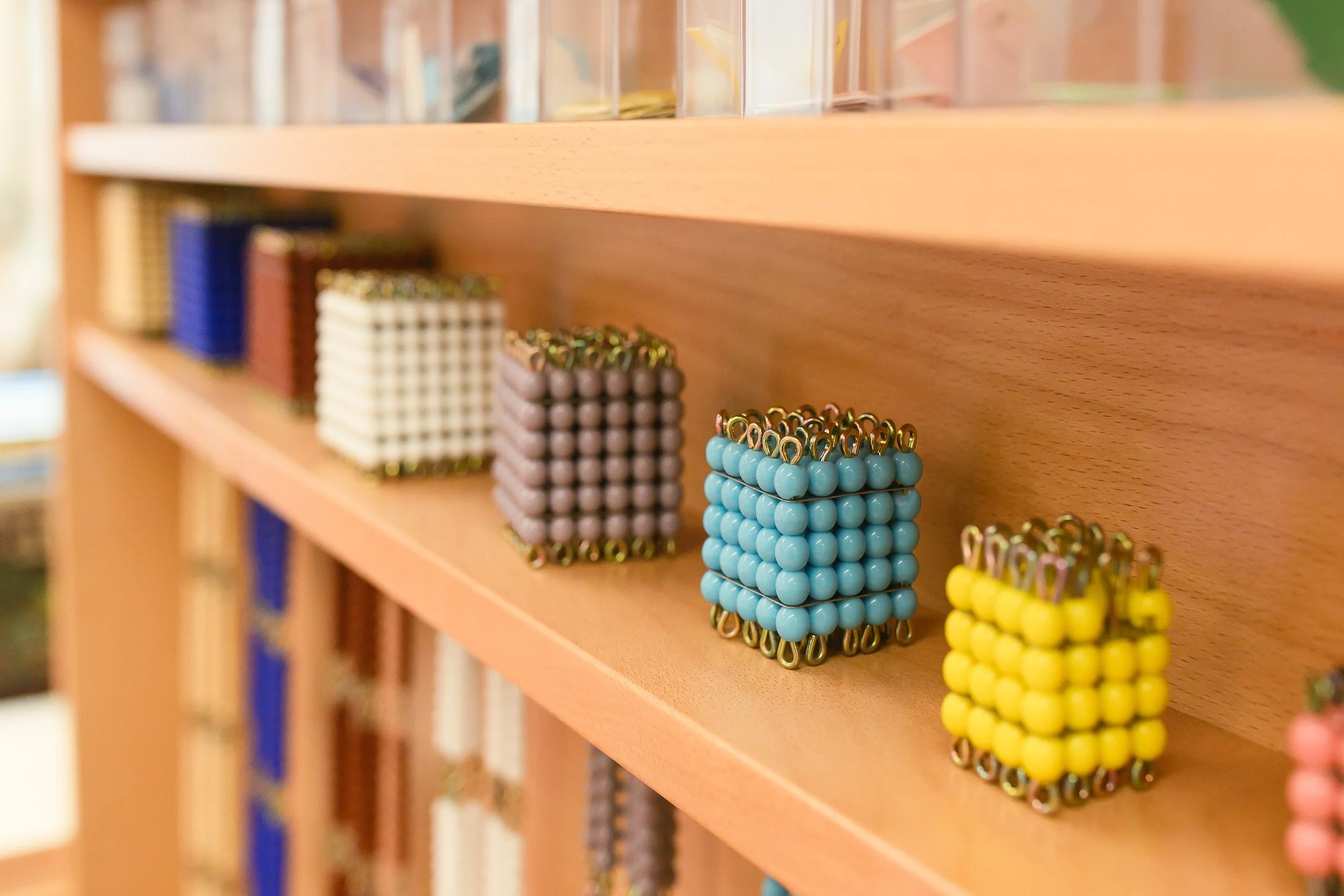 Colorful bead bracelets arranged on wooden shelves in a store.