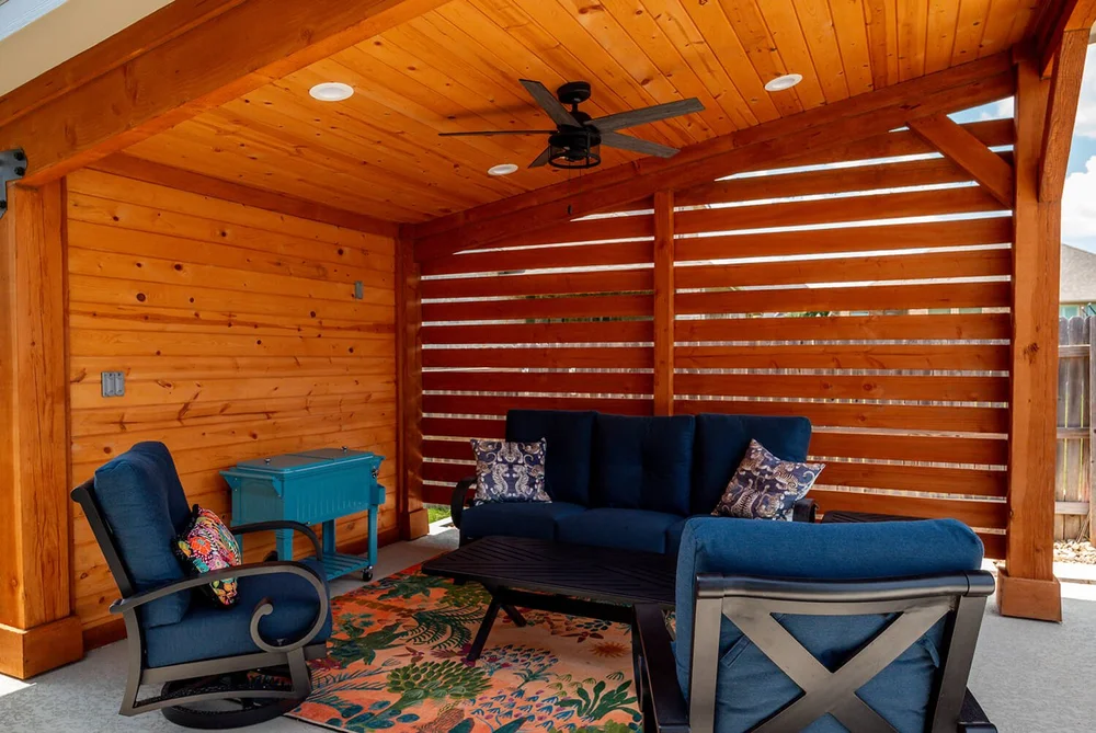 Outdoor patio seating area with ceiling fan and wood ceiling