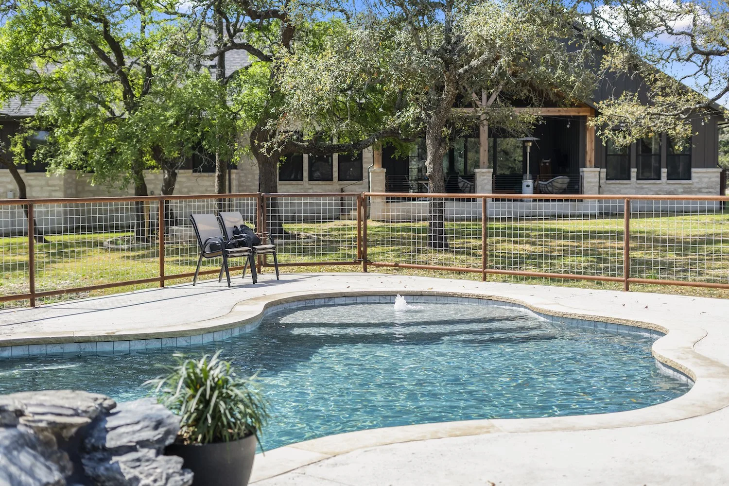 Custom gunite pool with boulder waterfall built by Aqua Logistics Custom Pools in Leander, Texas