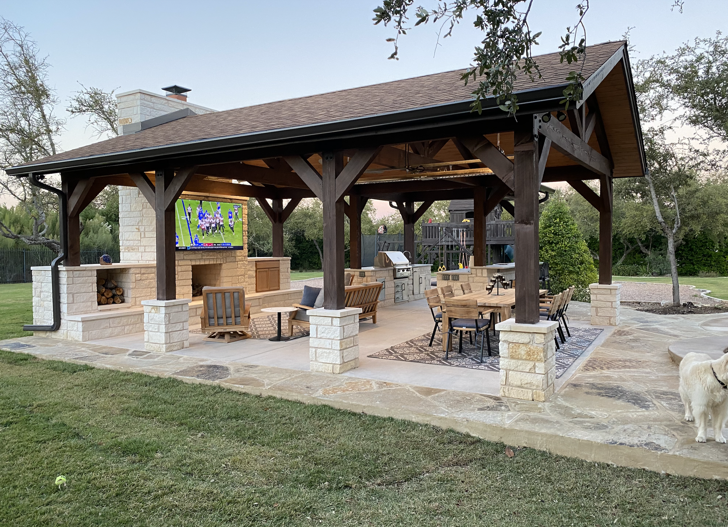 Custom outdoor living space with pergola and outdoor kitchen by Aqua Logistics Custom Pools in Austin, Texas