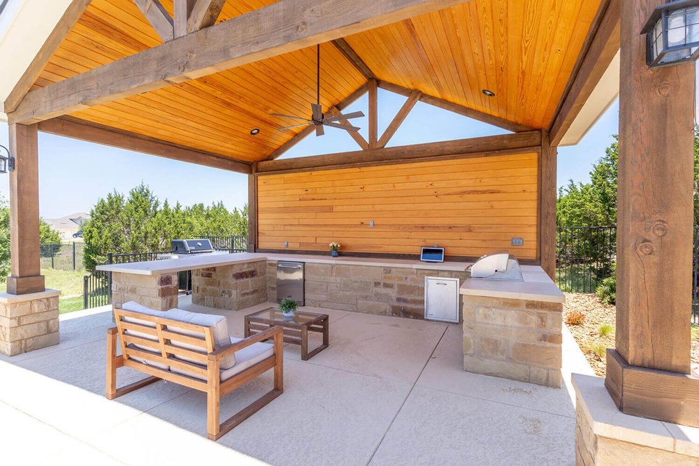 Covered outdoor patio with built-in grill and ceiling fan