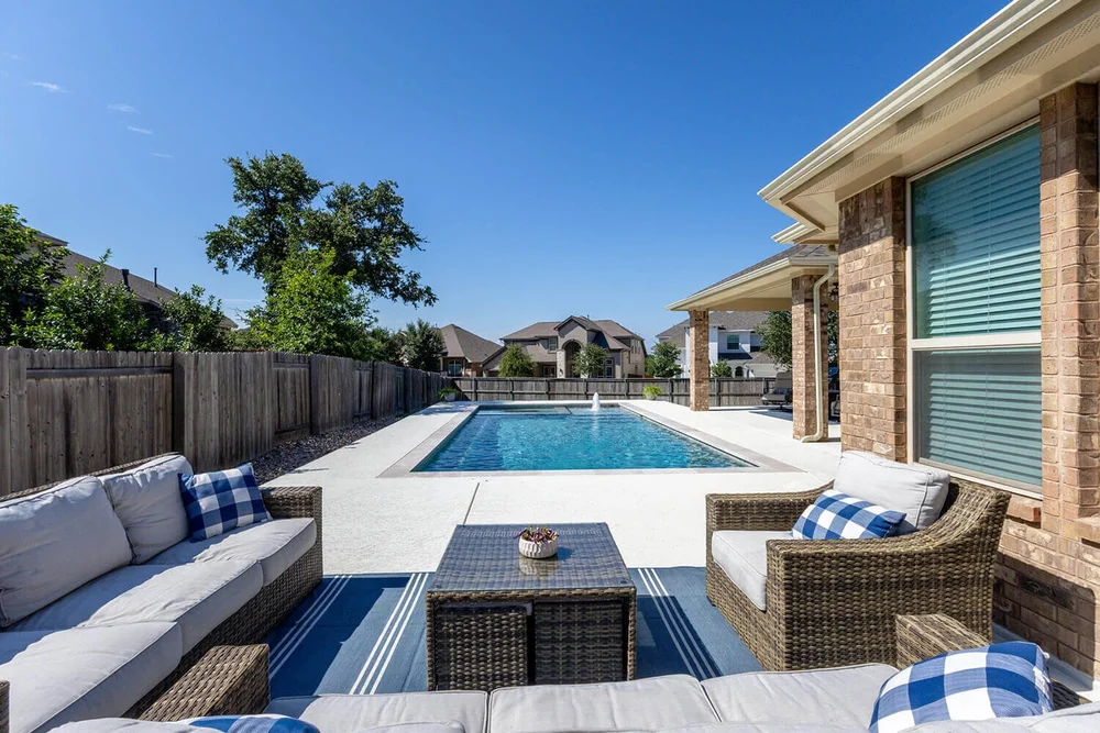 Backyard pool with patio furniture — Austin TX