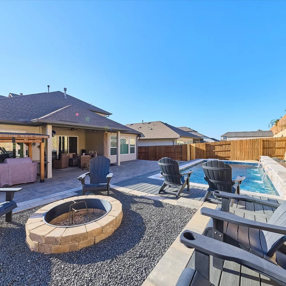 Outdoor seating area alongside custom pool in New Braunfels