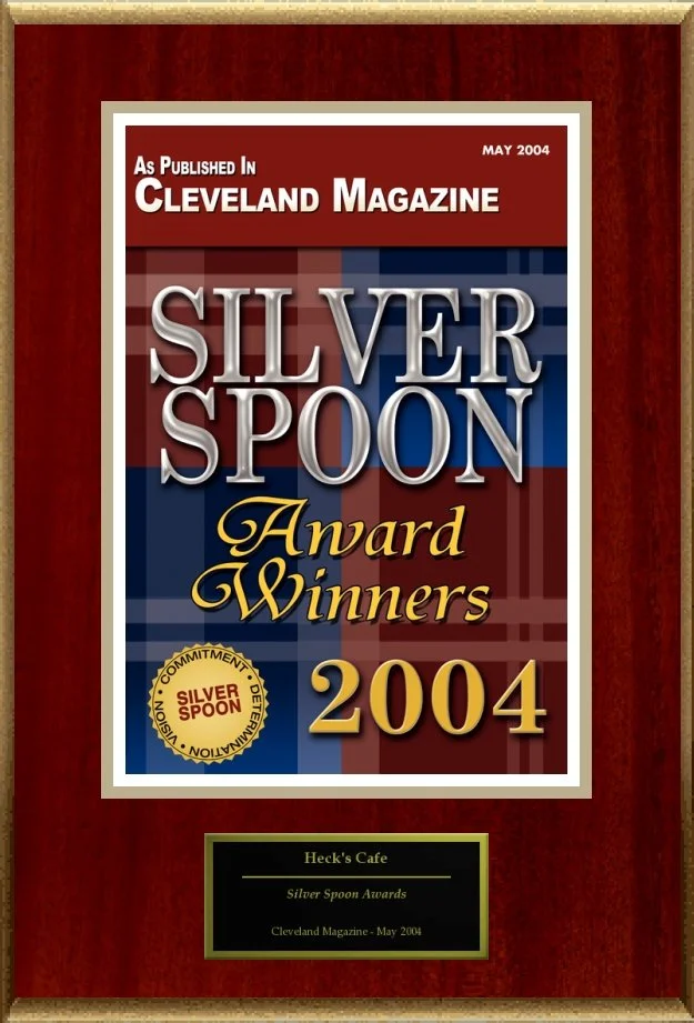Silver Spoon Award plaque from Cleveland Magazine May 2004, awarded to Heck's Cafe for commitment and innovation, displayed in gold and red.