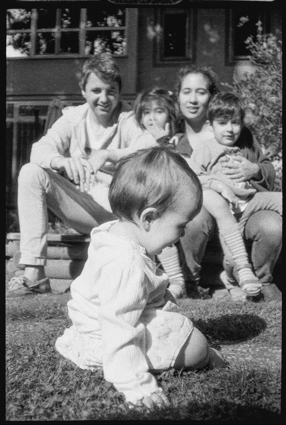 Familie sitzt lachend gemeinsam im Garten – Familienfotografie in Frankfurt und Mainz