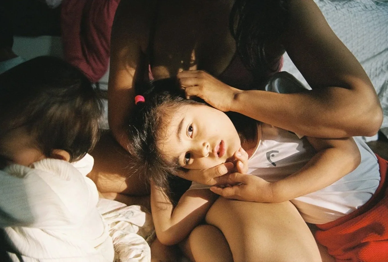 Mutter hält Tochter im Arm, Tochter schaut in die Kamera – Familienportrait zu Hause in Mainz