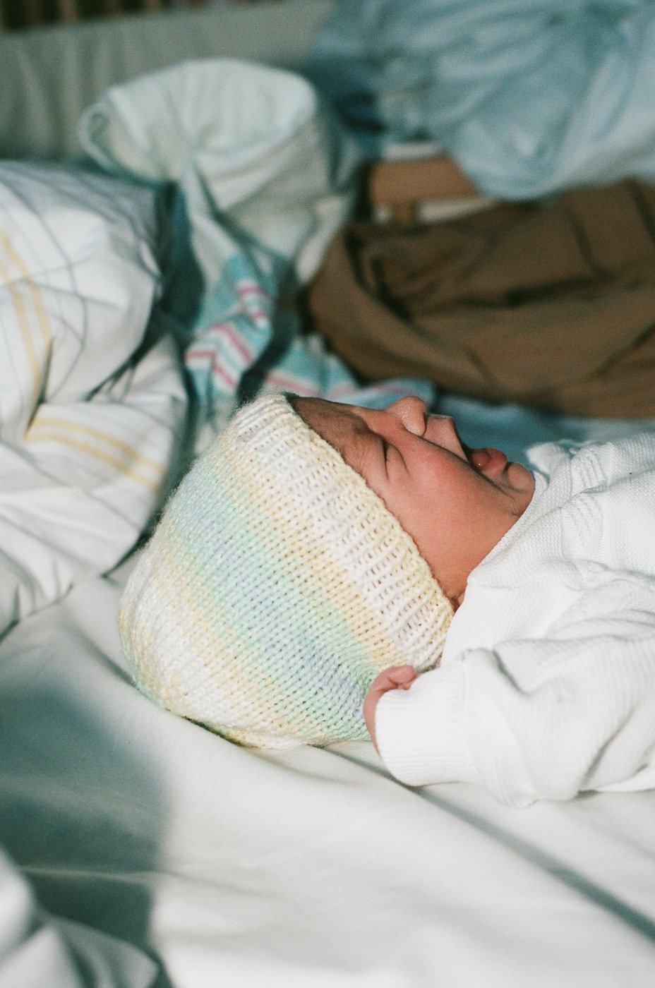 Neugeborenes weinend auf Bett nach der Geburt in Wiesbaden im Krankenhaus analog fotografiert
