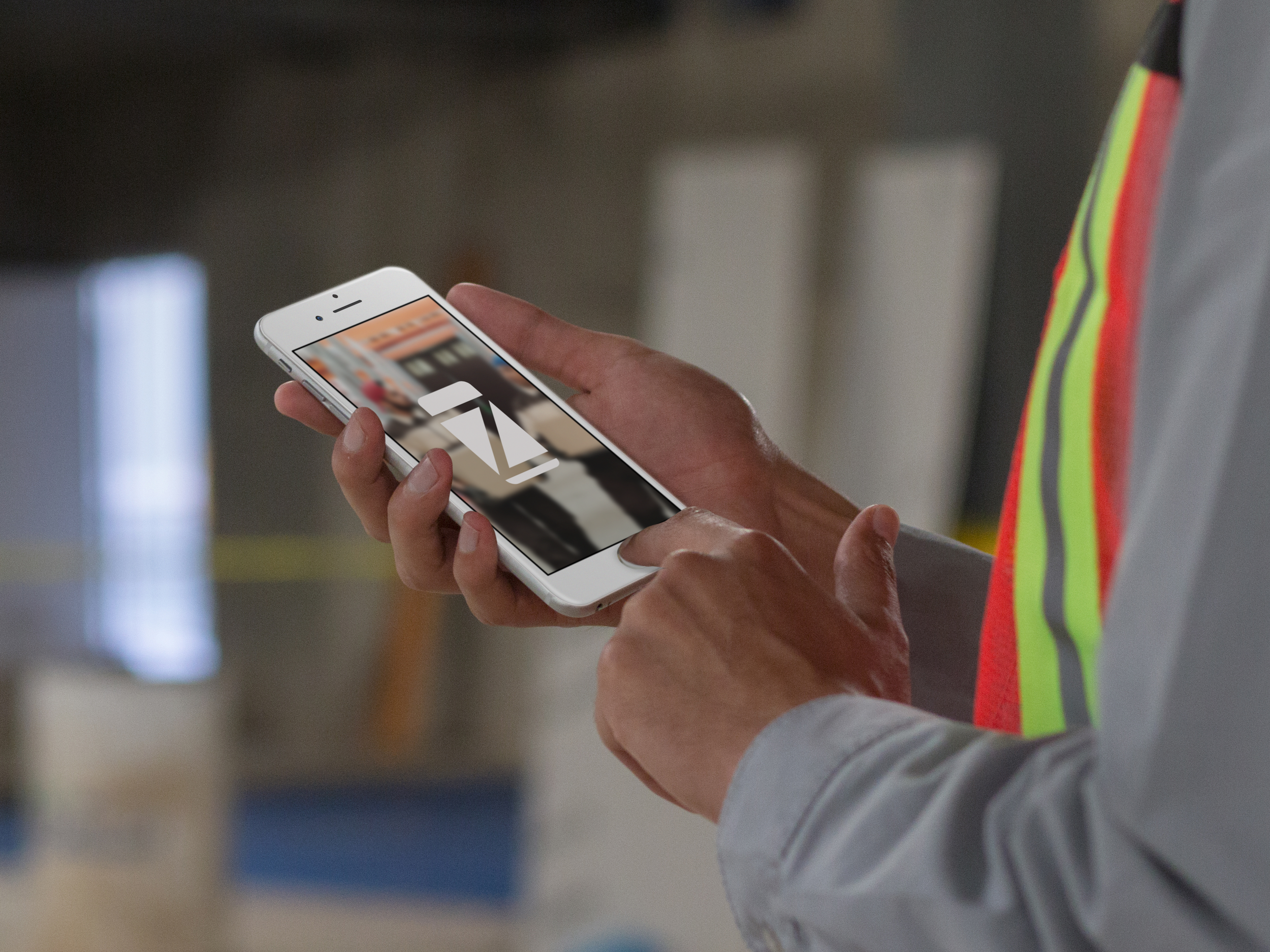 mockup-of-a-man-working-in-a-factory-holding-an-iphone-in-portrait-position-12585.png