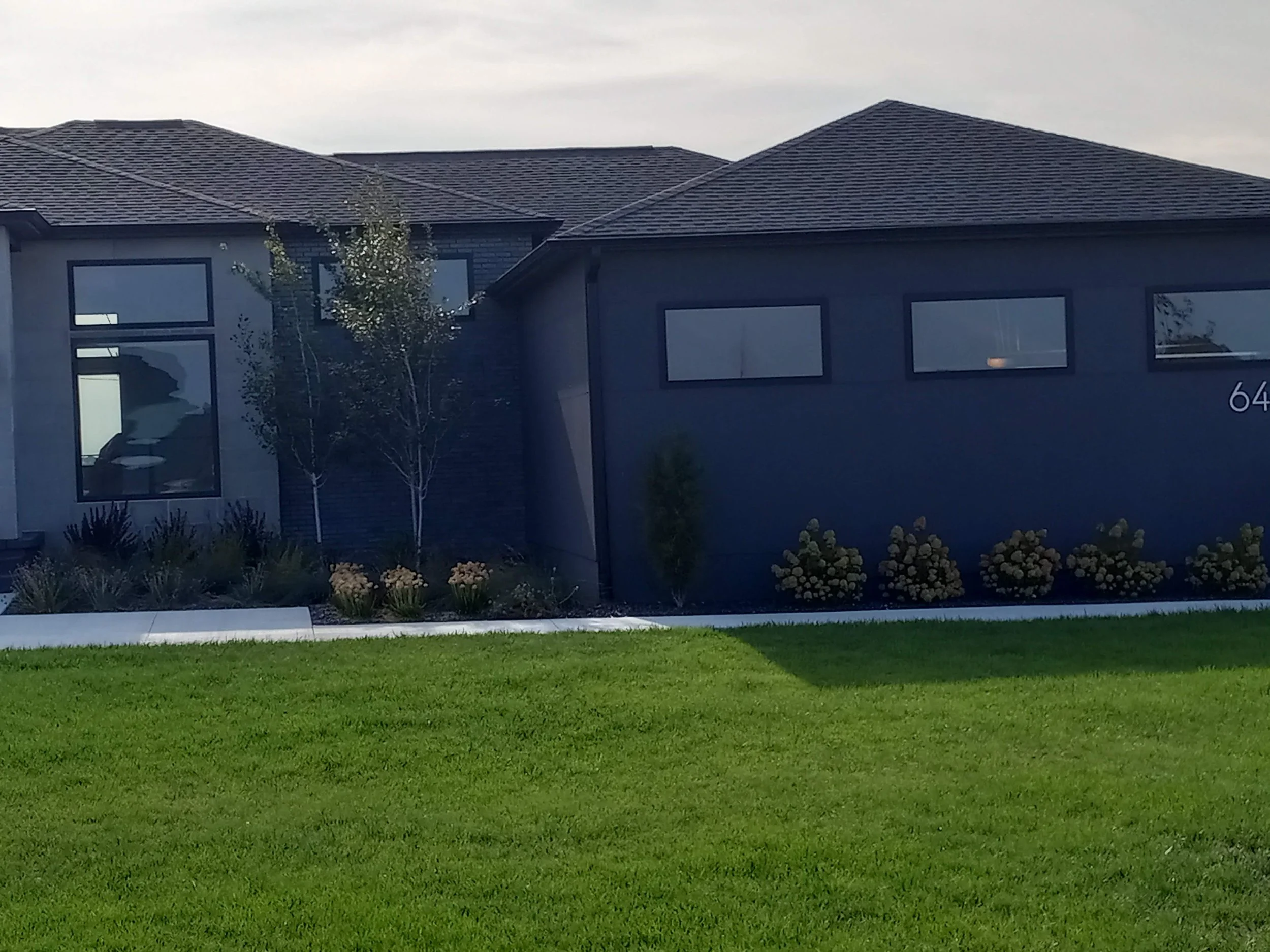 Modern house with large windows and well-maintained lawn