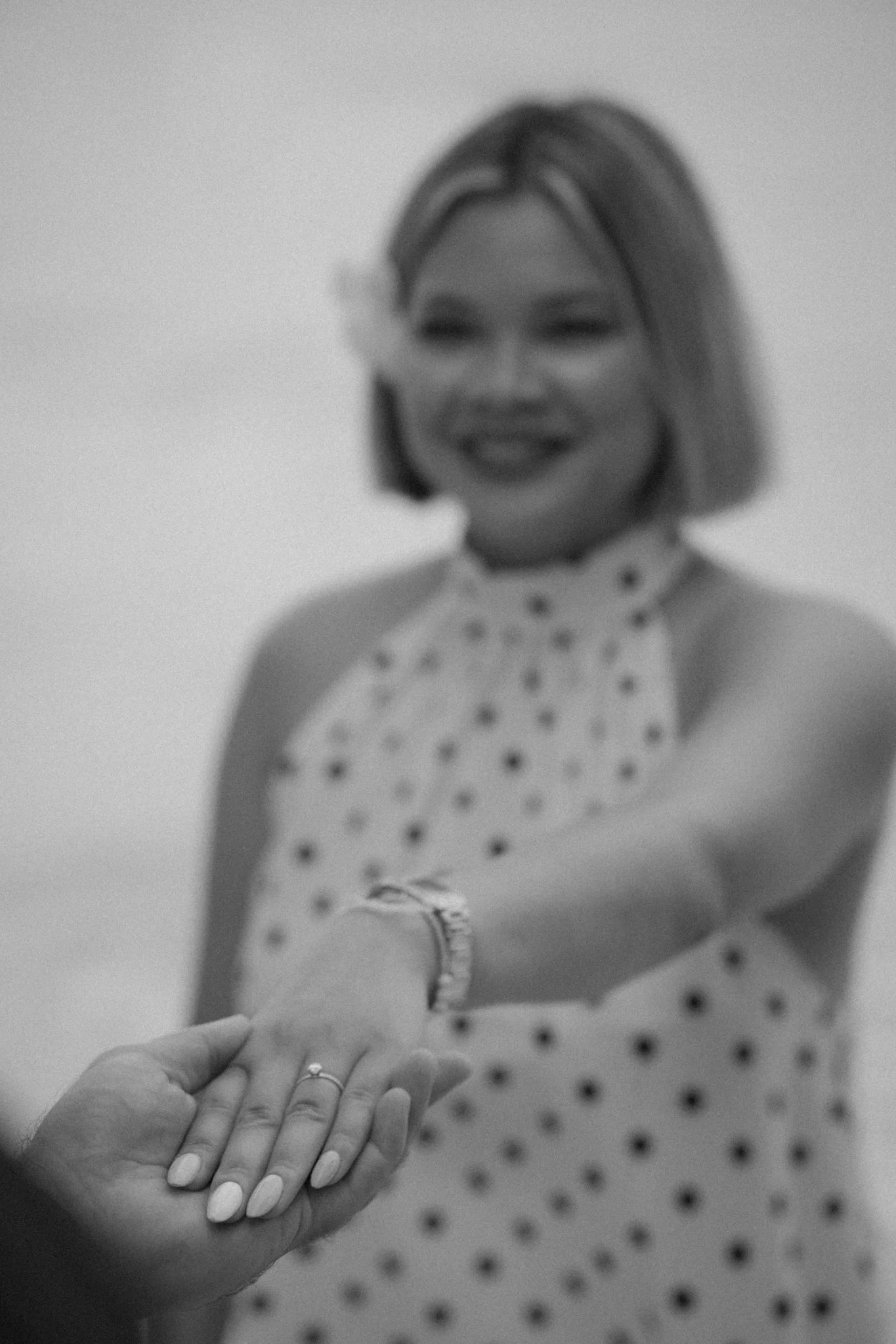 A woman in hospital gown holding out her hand for a handshake with a person whose hand is visible.