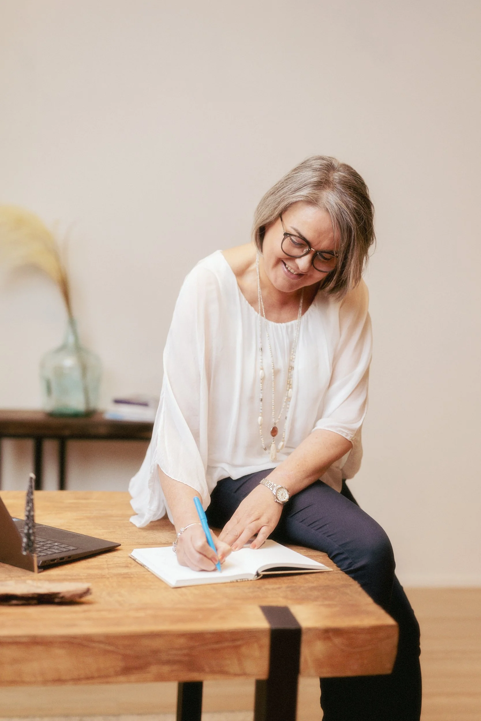 Purovesi Partners, Outi Purovesi hymyilee kirjoittaessaan muistiinpanoja.