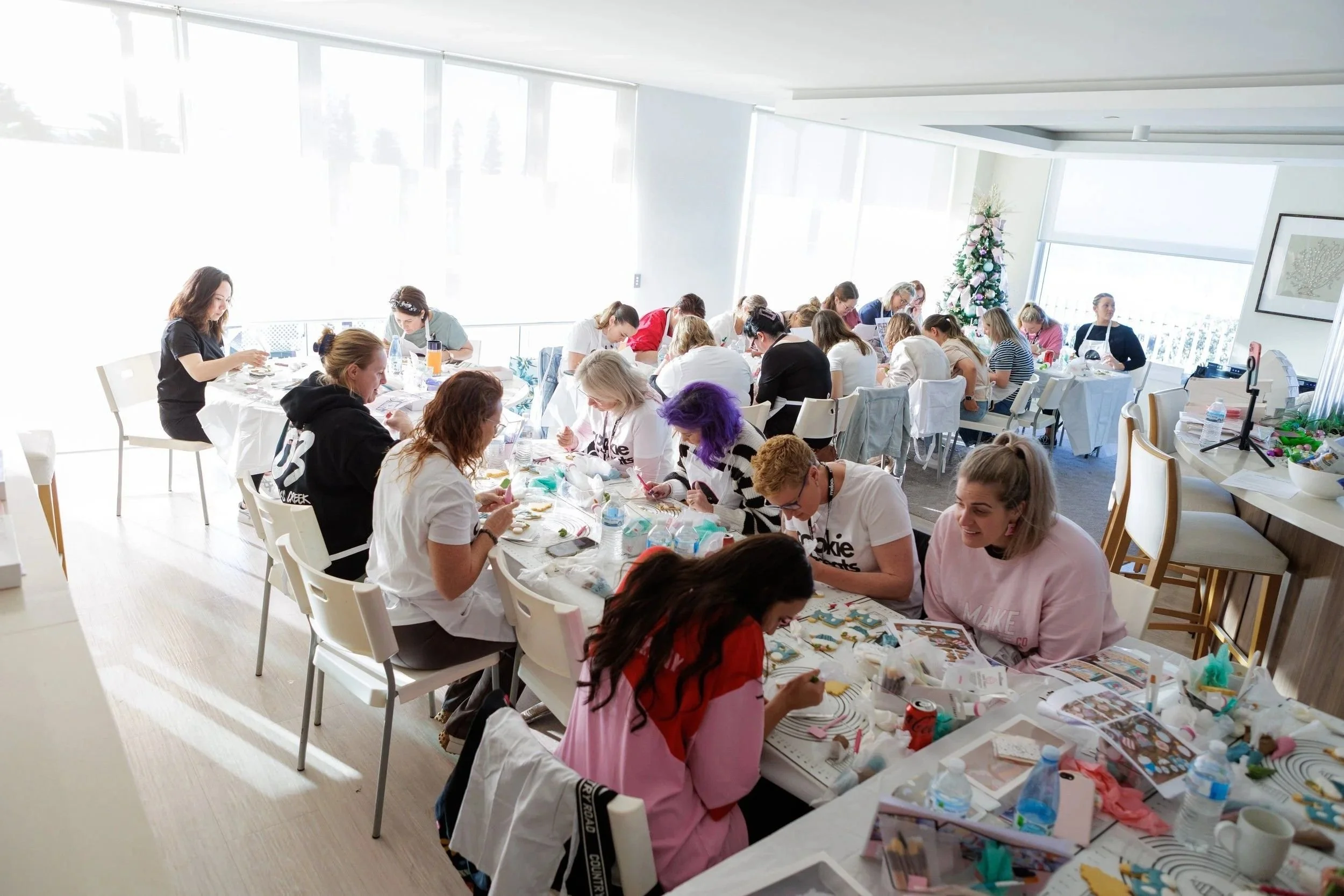 Women at tables decorating cookies