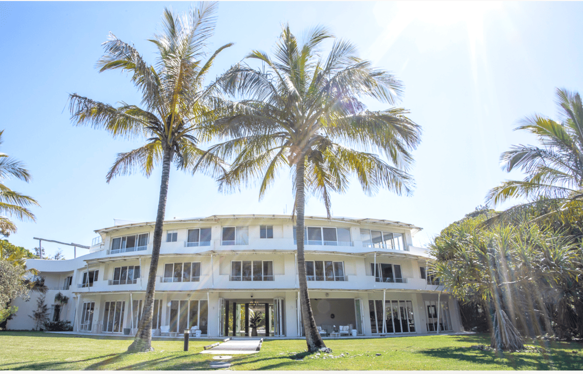 Exterior of white building with palm trees where the retreat is held