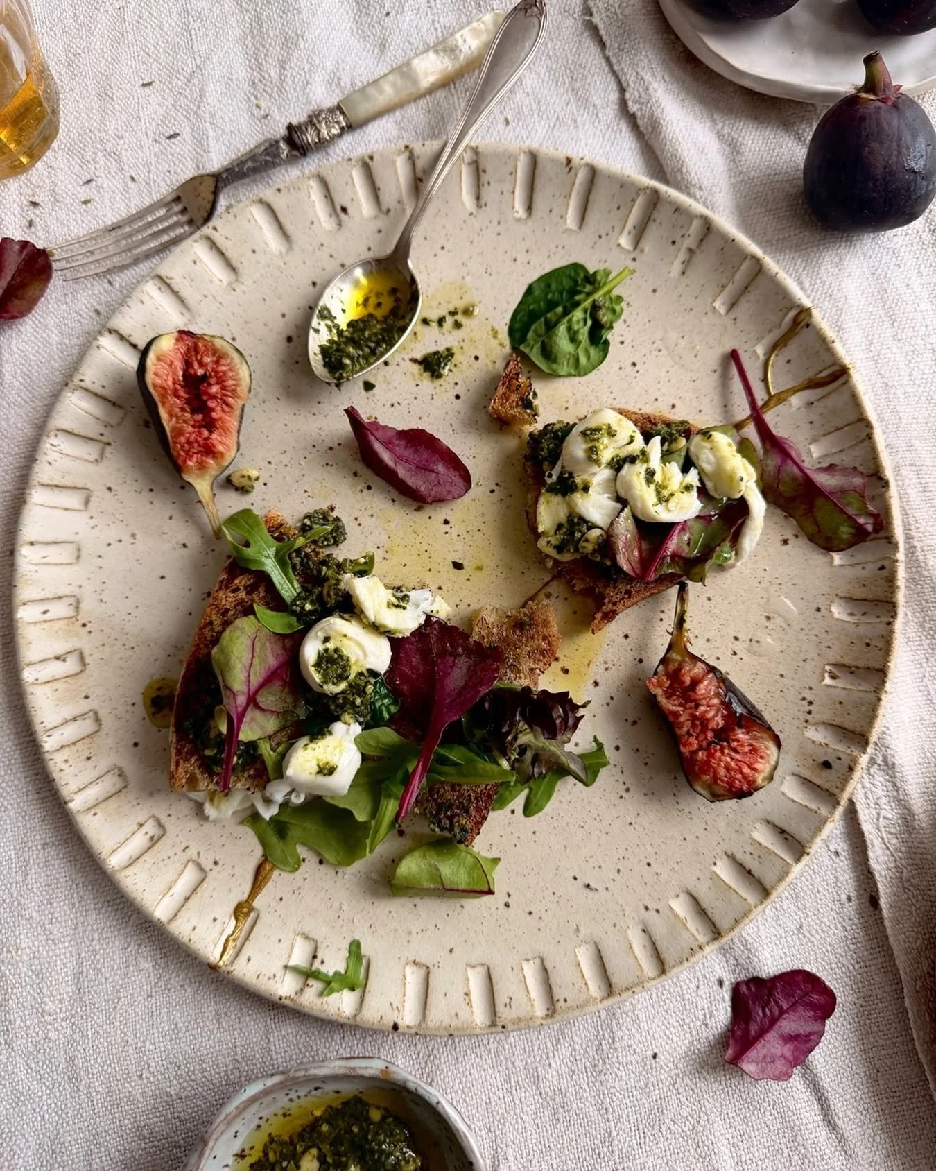 Birds eye view shot of a plate with purple and green based foods on a linen tablecloth