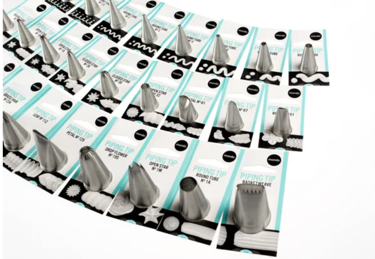 Set of piping tips for cake decorating arranged on a circular display.