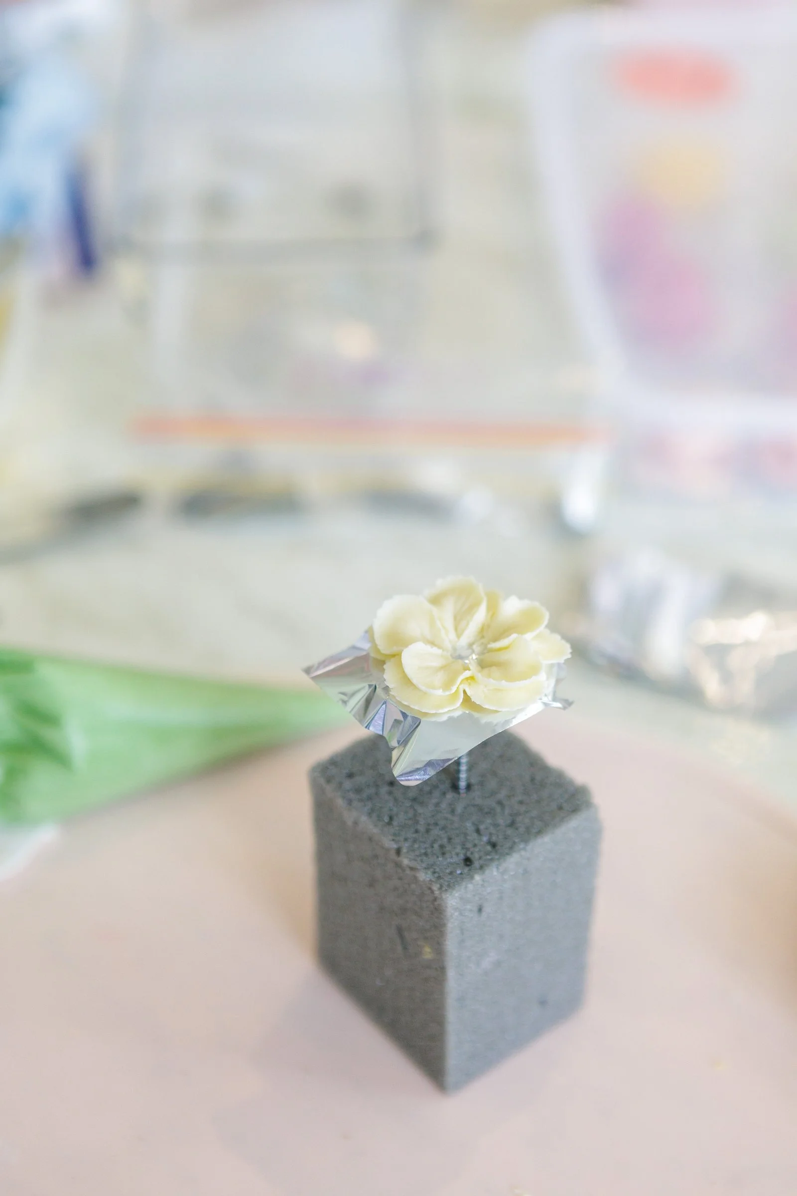 A single piped buttercream flower on a foam block at the 2026 Cupcake Retreat