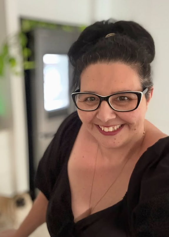 Mel in a black short smiling in the kitchen