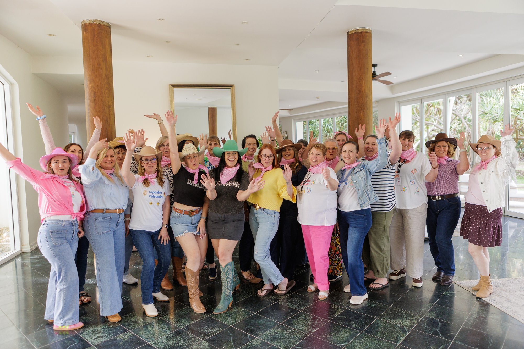 Guests in pink cowgirl hats celebrating at the end of the meloo Cupcake Retreat