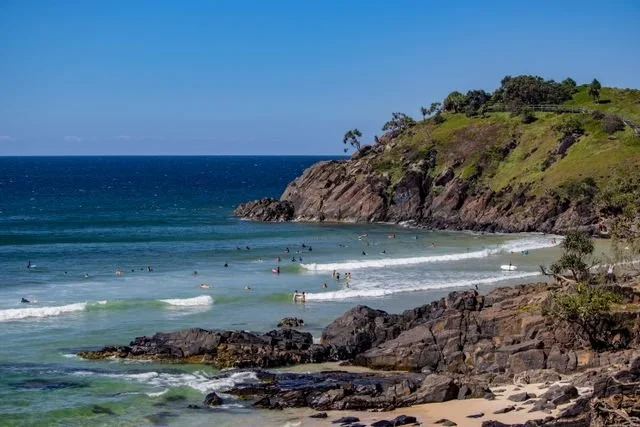 Headland and beach at Cabarita with people swimming