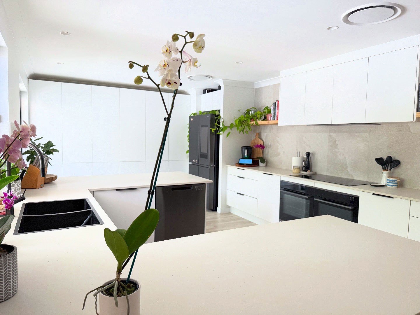 White modern kitchen with a Thermomix on the counter in the distance