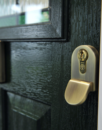 Brass door handle and lock on a dark green painted door