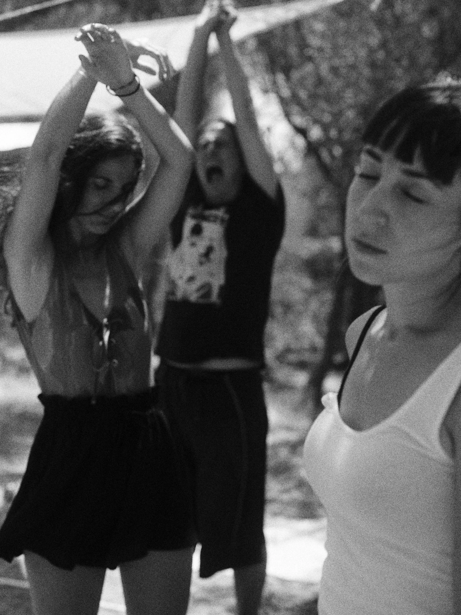 Tres personas en un parque, dos de ellas parecen estar relajadas, una mujer con barba y otra con cabello largo y oscuro y una mujer con cabello corto, parece que están disfrutando del día.