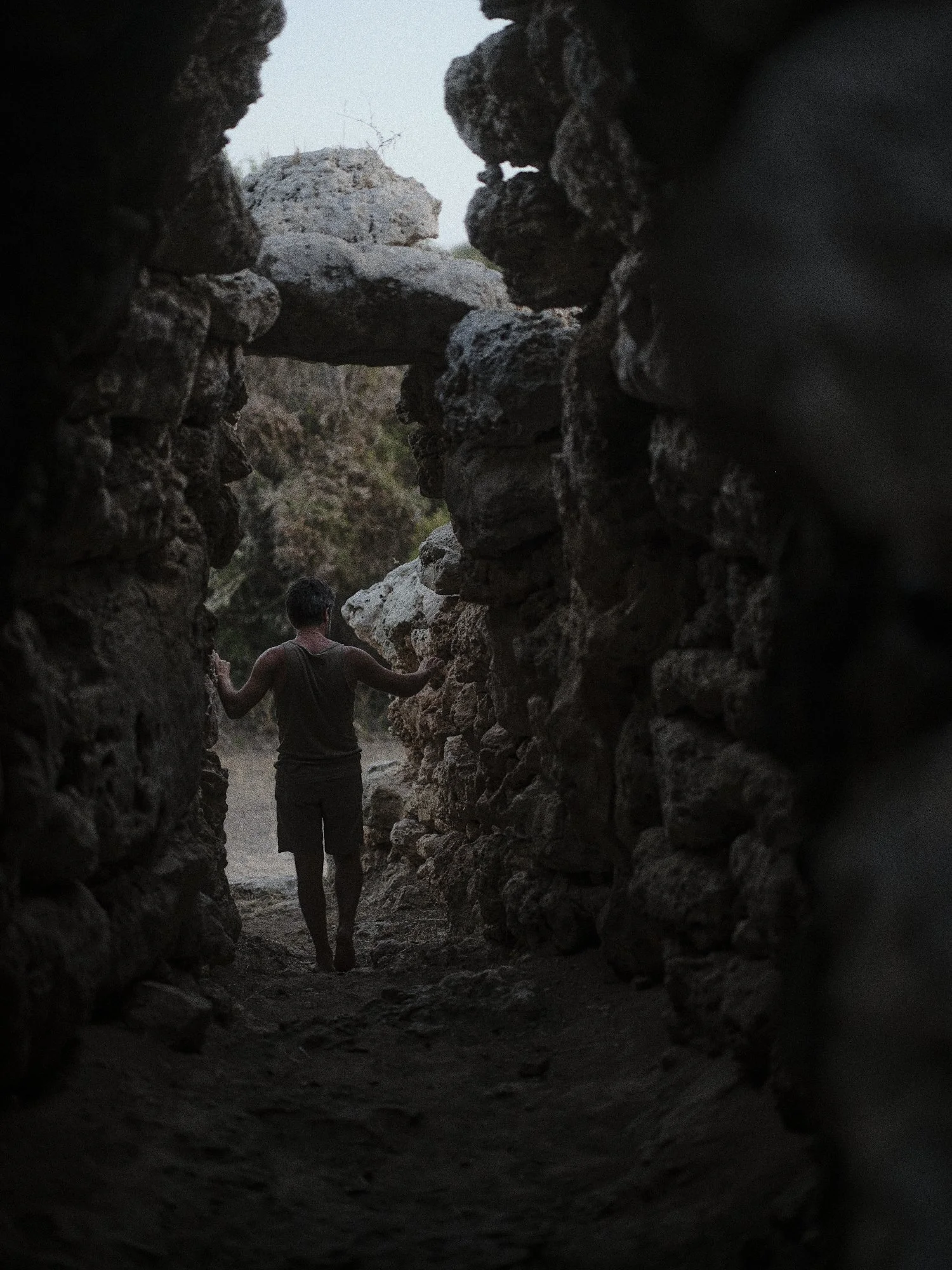 Persona caminando entre viejas ruinas de piedra al atardecer o amanecer.