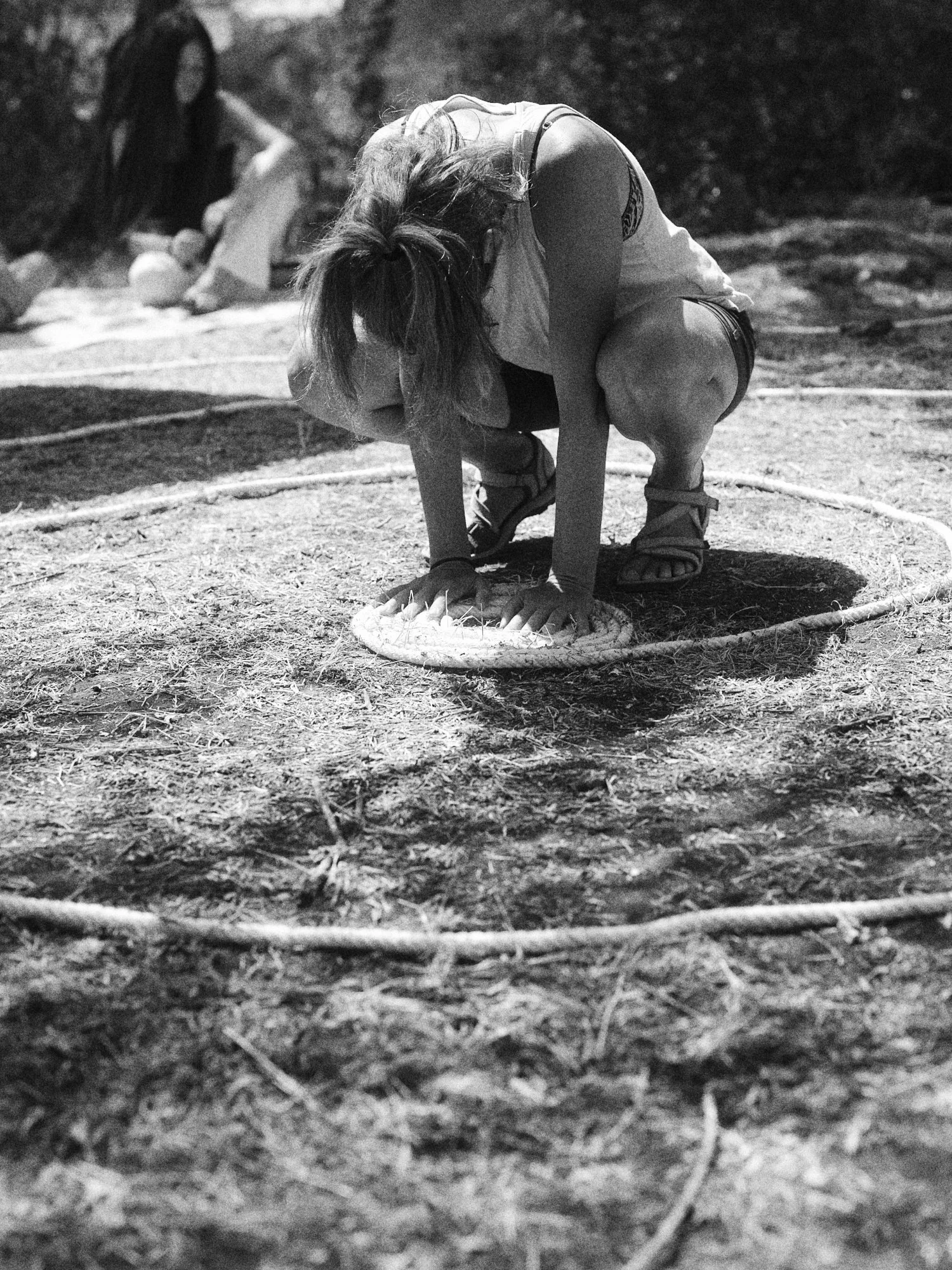Niña en un acto de juego saltando en círculo en un espacio al aire libre.