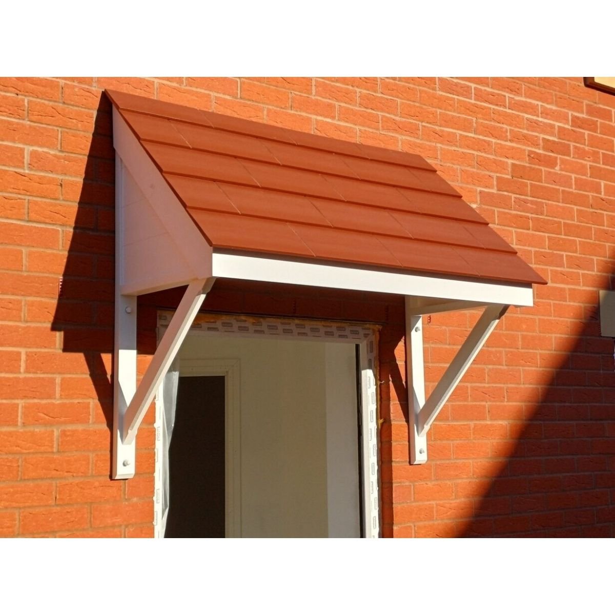a white pitched door canopy with a terracotta roof on a brick wall