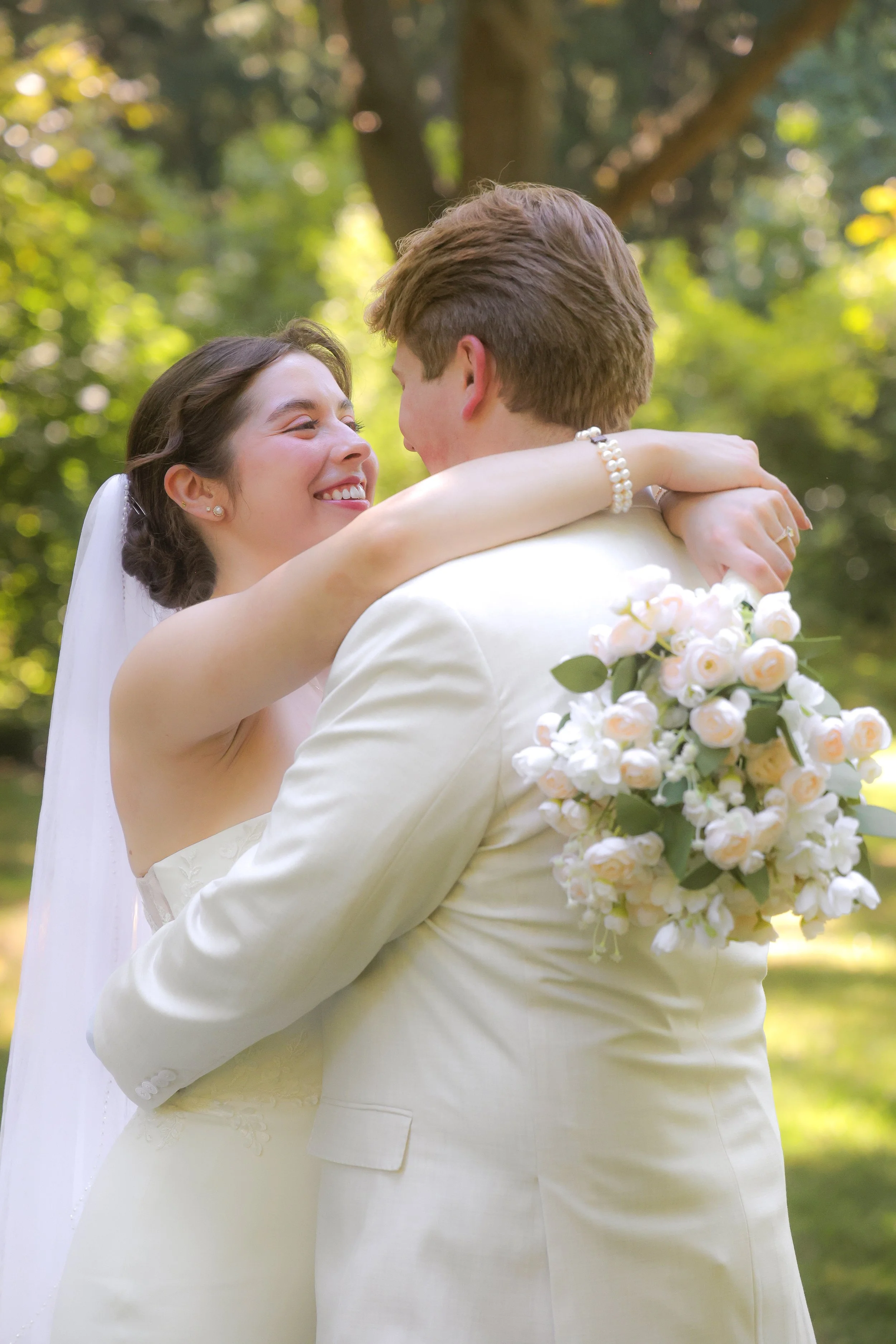 A bride and groom share a joyful embrace outdoors in summer wedding ceremony captured by wedding photographer in Indianapolis