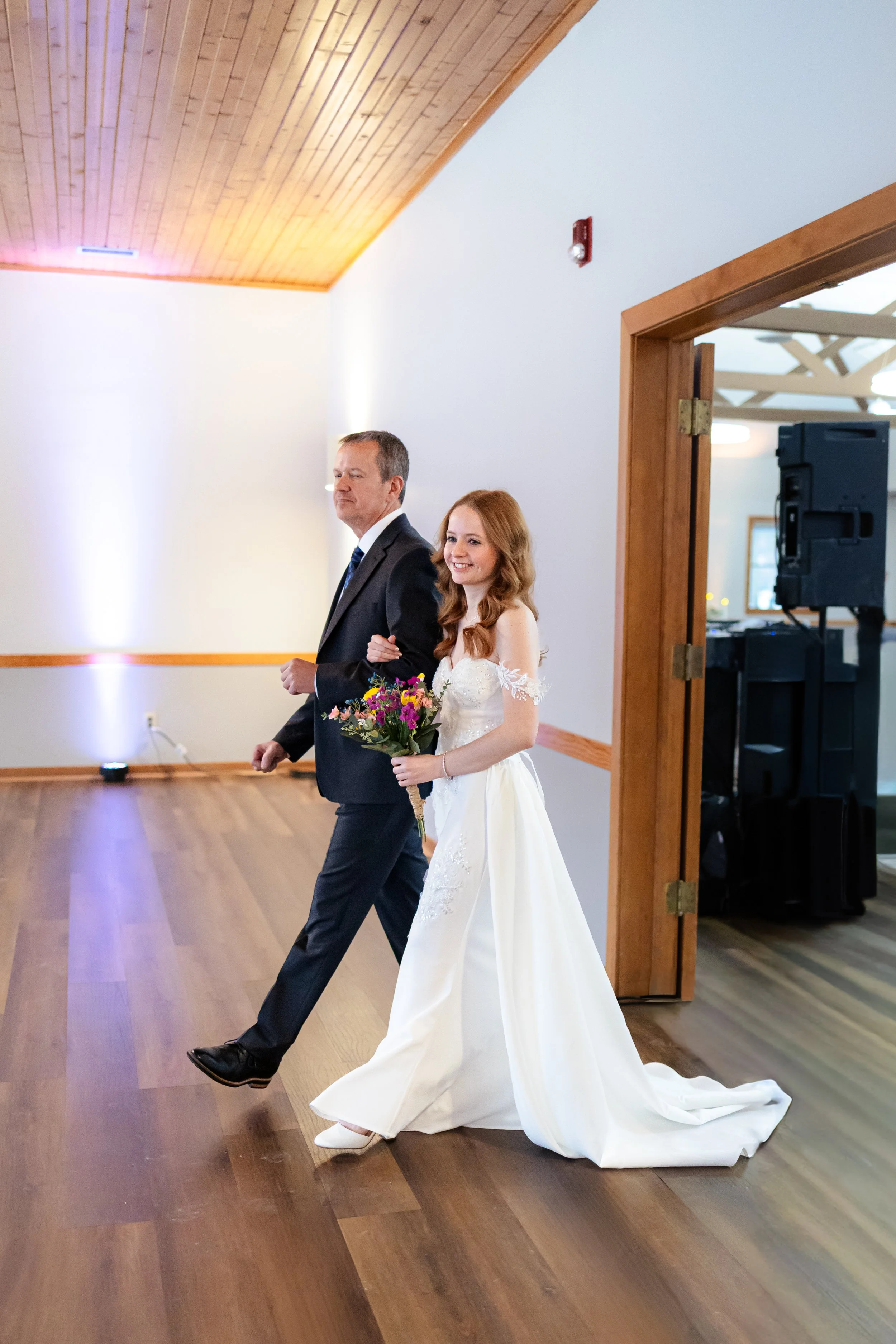 Father of the bride walking the bride down the aisle during winter wedding ceremony captured by Indianapolis wedding photographer in Noblesville, Indiana