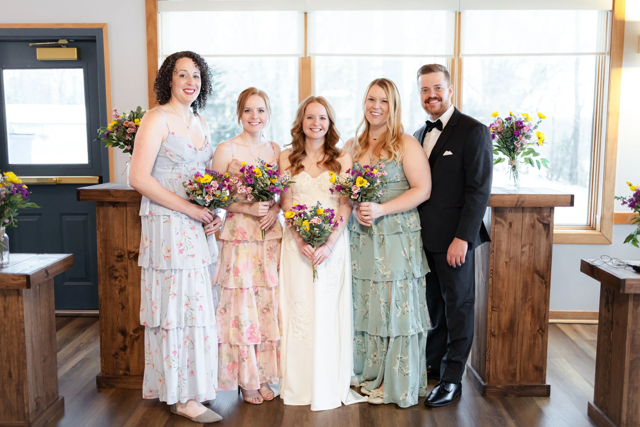 Bridal party with bridesmaids posing for group photos at indoor winter wedding ceremony captured by wedding photographer in Indianapolis