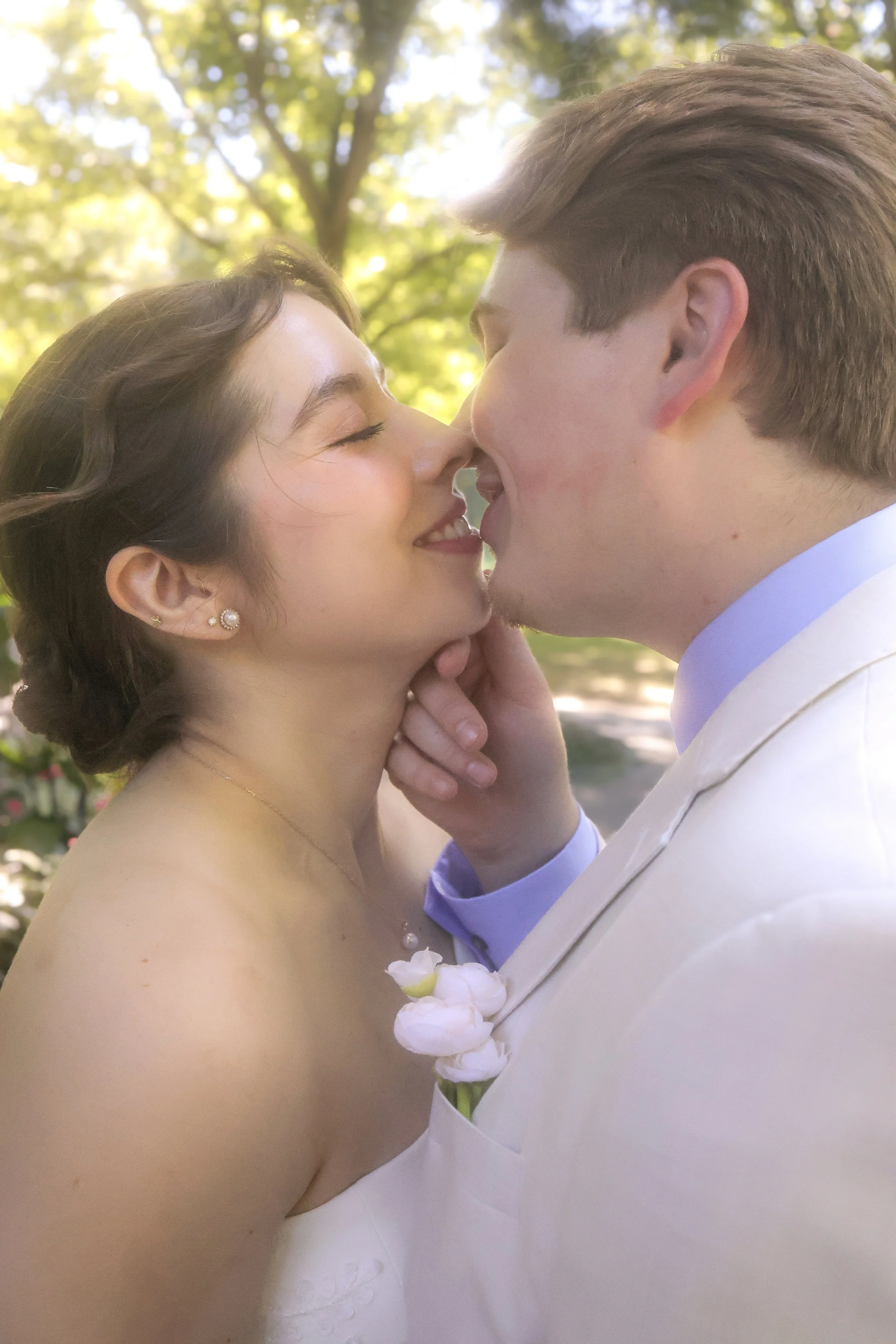 A bride and groom sharing a kiss in outdoor summer wedding ceremony captured by wedding photographer in Indianapolis