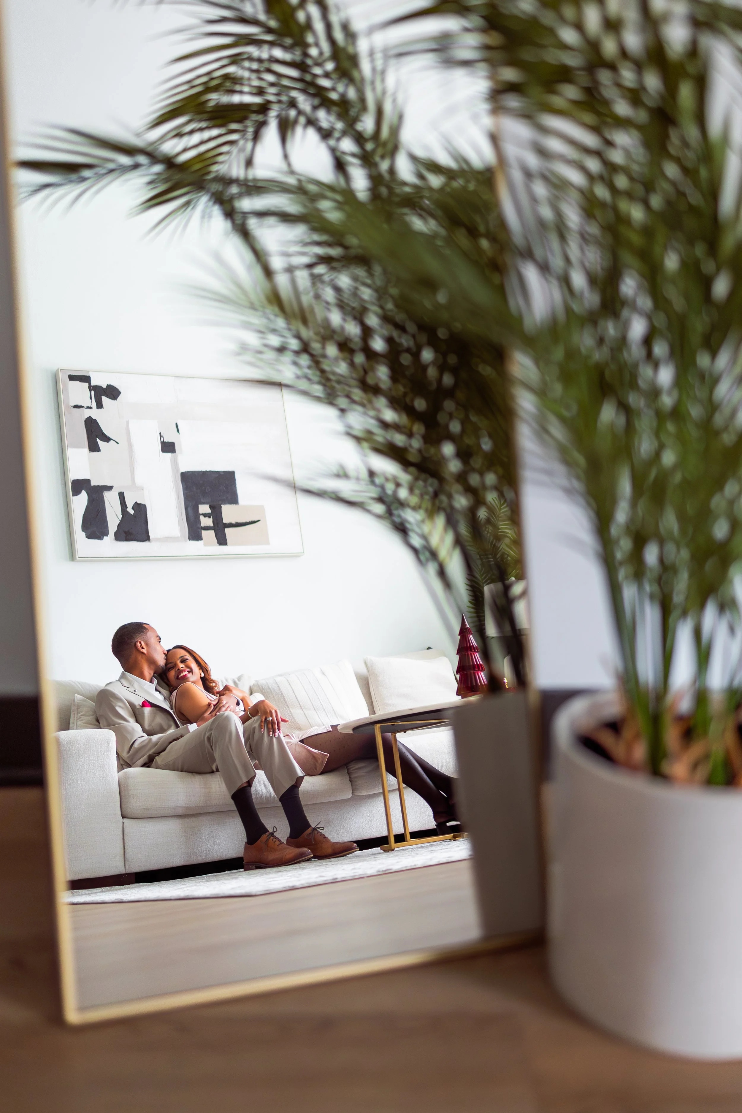 Married couple cuddling together on sofa during couples holiday photo session in their home captured by Indianapolis couples photographer