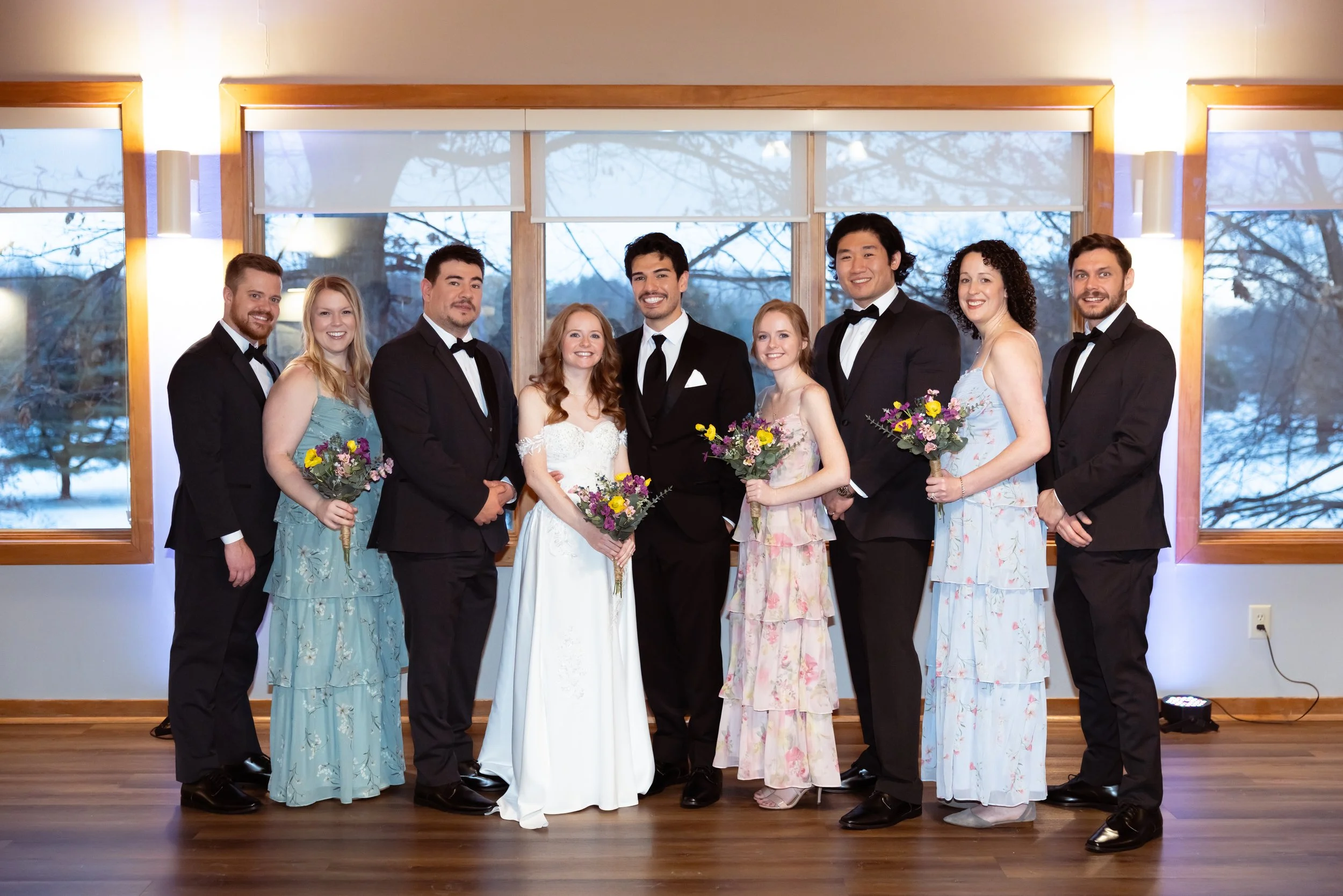 Wedding party posing for group photos at indoor winter wedding ceremony captured by Indianapolis wedding photographer in Noblesville, IN