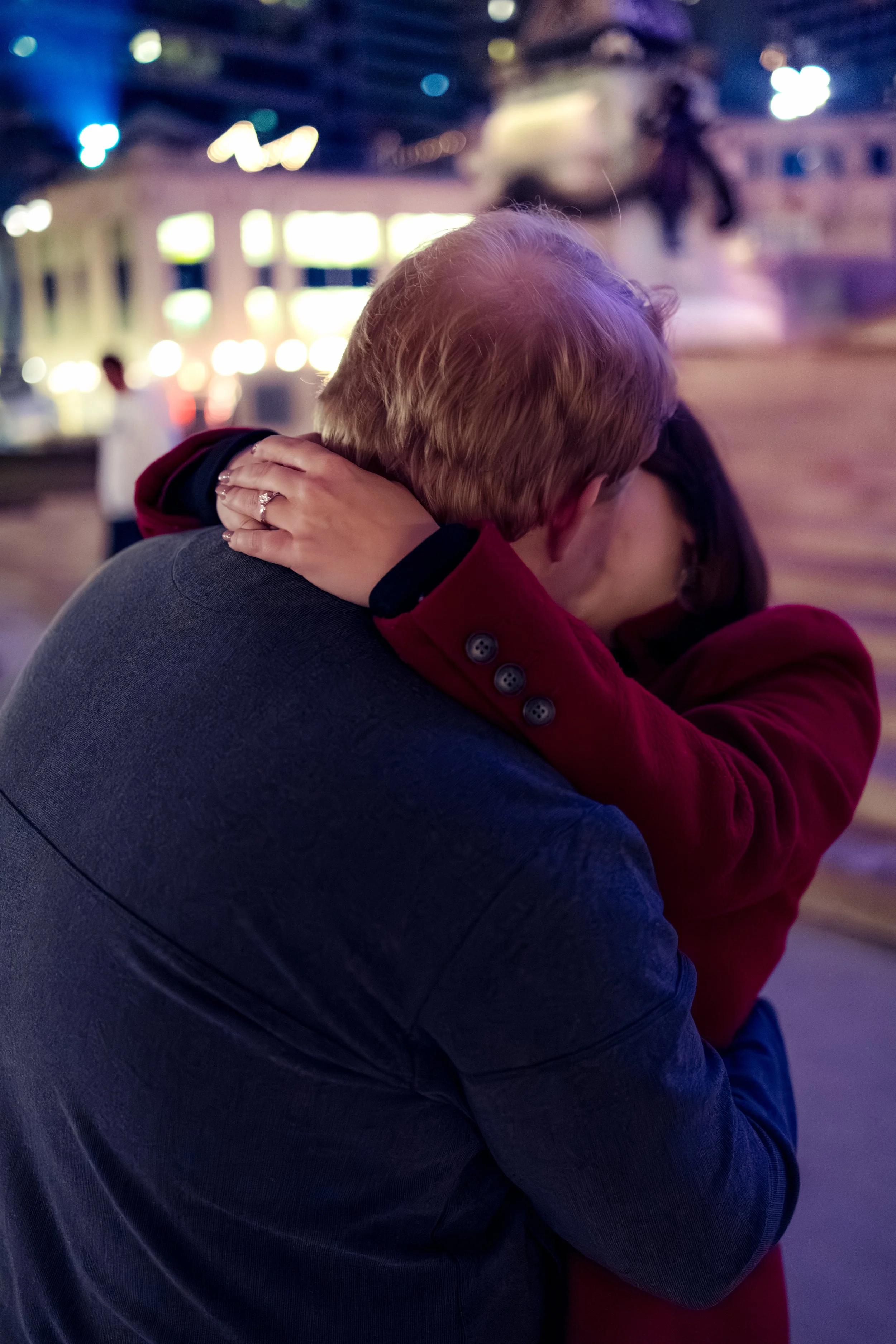 Engaged couple kiss after proposal captured by engagement photographer at Soldiers and Sailors Monument in Downtown Indianapolis