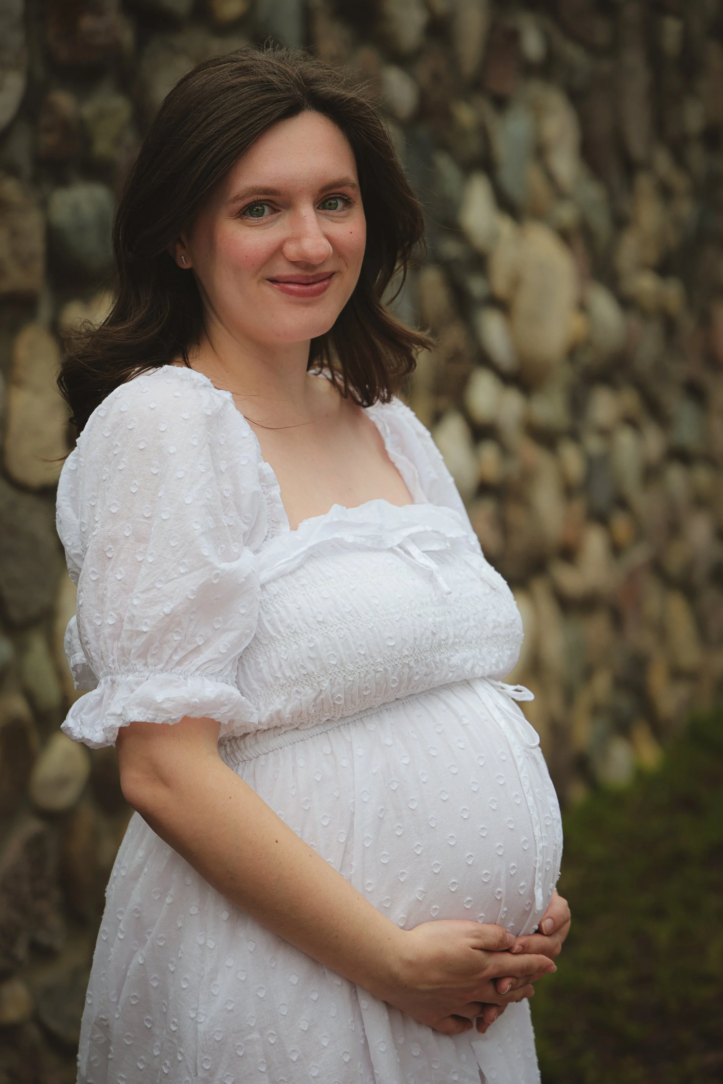 A pregnant woman during maternity photo session in the summer time posing for Indianapolis family photographer at an outdoor park in Carmel, Indiana