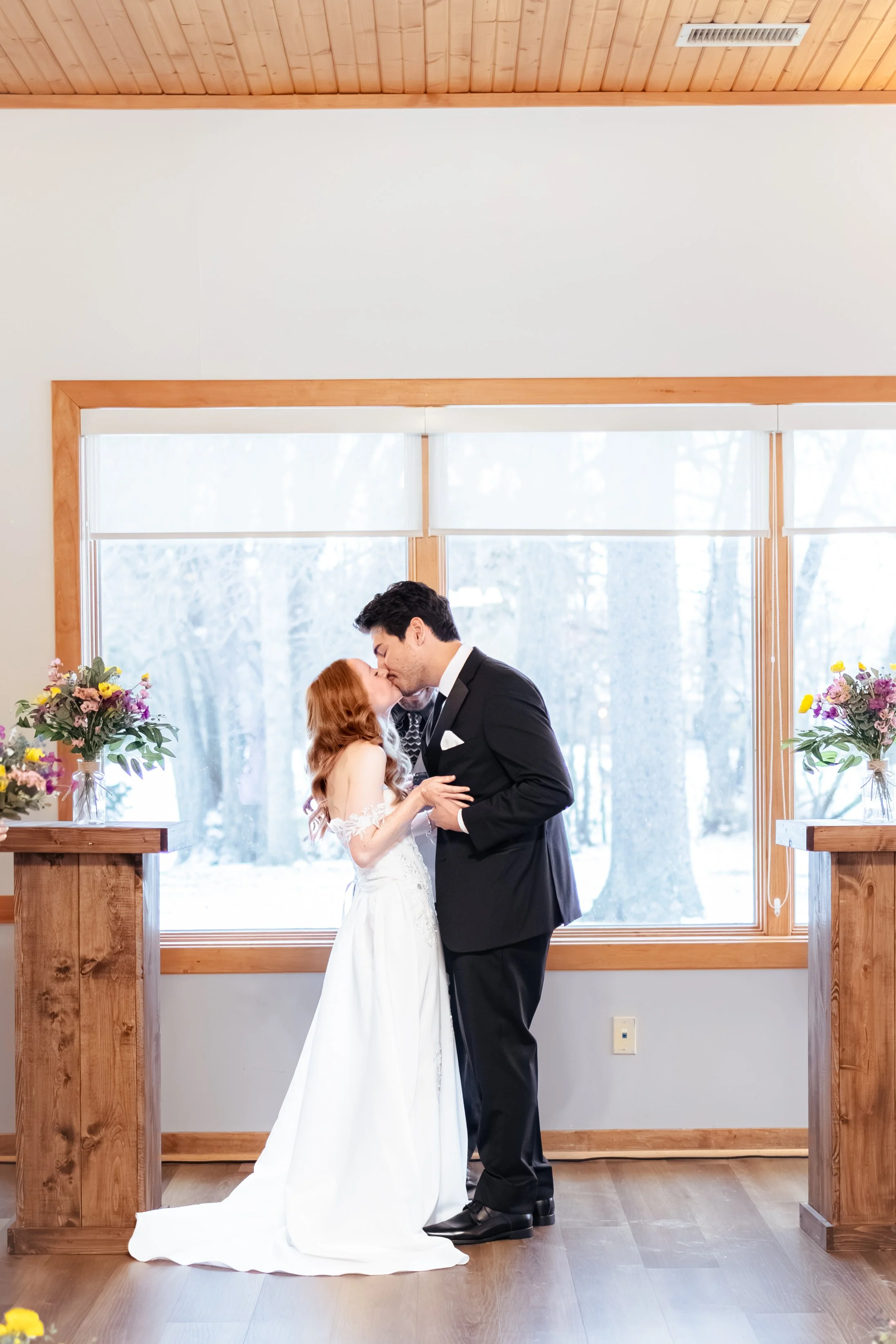 Bride and groom sharing first kiss married during winter wedding captured by wedding photographer in Noblesville, Indiana