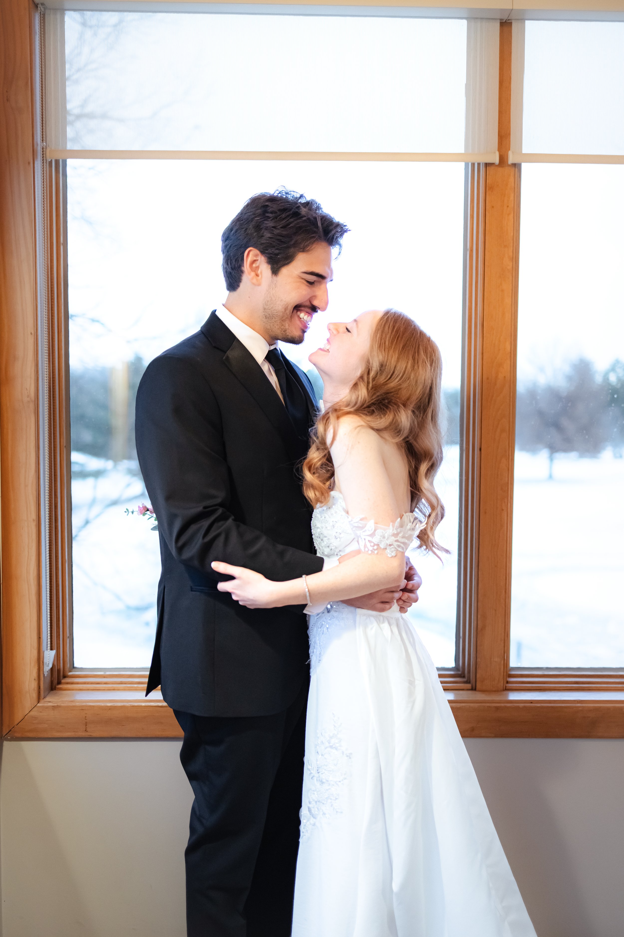A newlywed couple posing during couples portraits at their indoor winter wedding ceremony captured by wedding photographer in Indianapolis