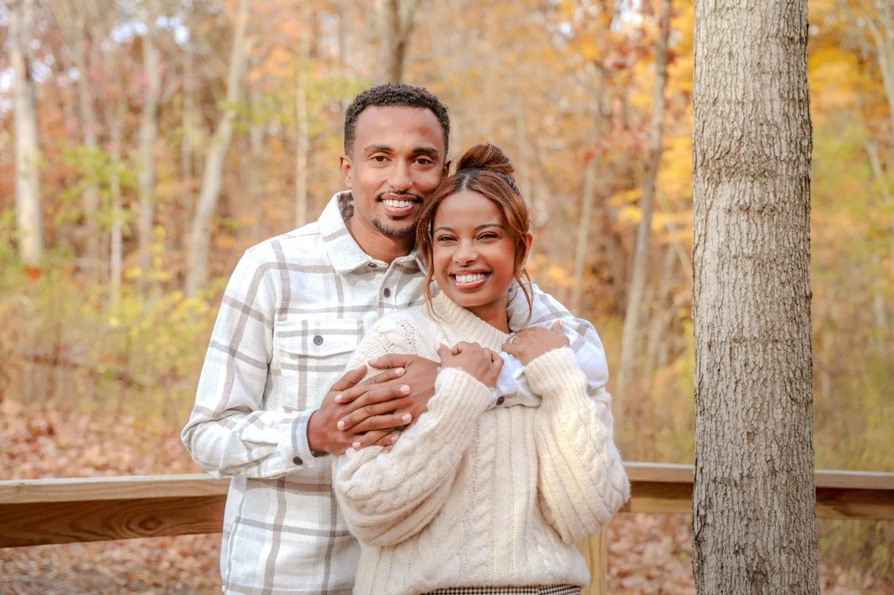Married couple posing together amongst the fall leaves during couples photo session in the fall at a park taken by Indianapolis couples photographer