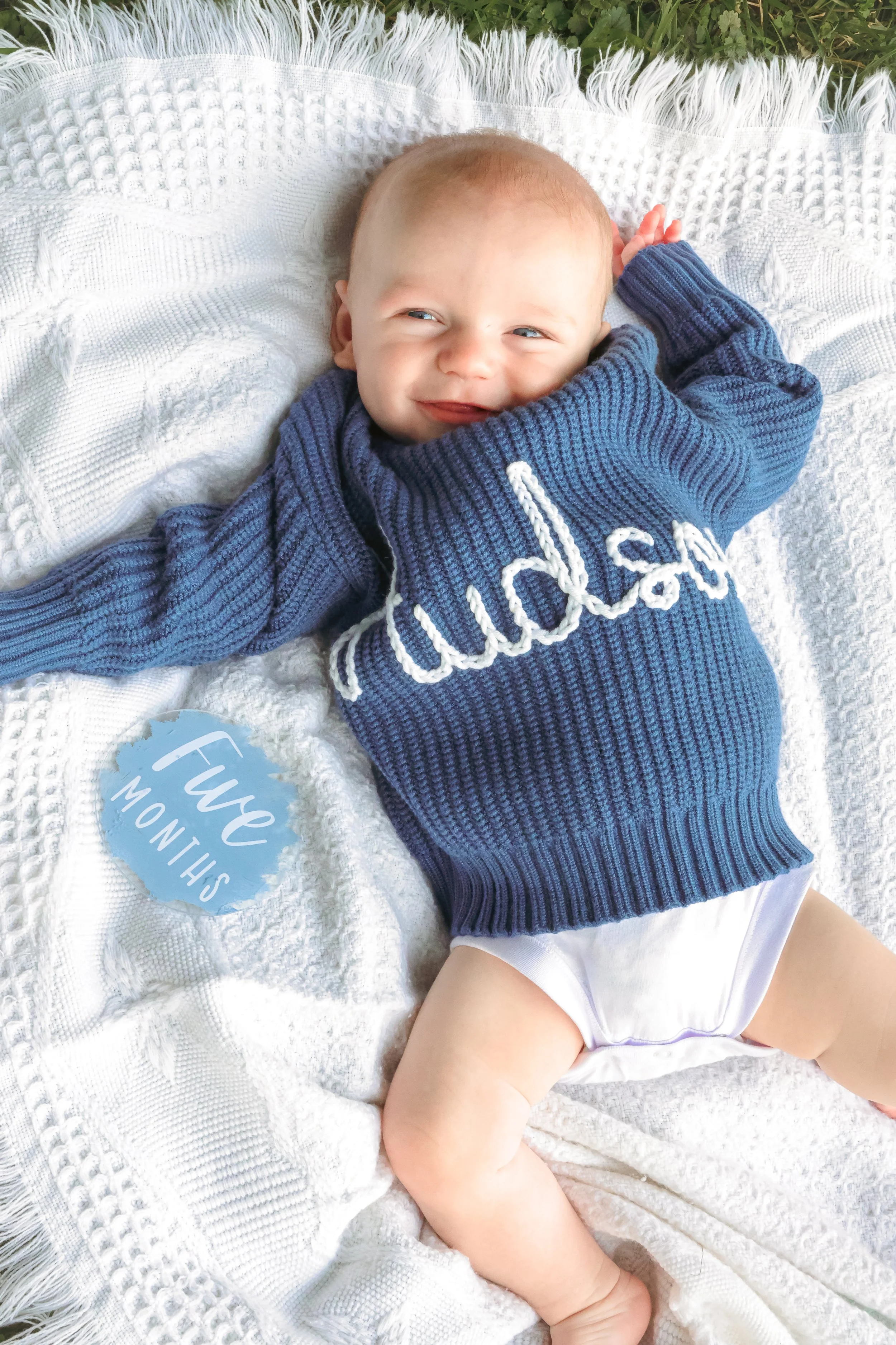 Baby smiling during family photo session in the summer at a park captured by Indianapolis family photographer